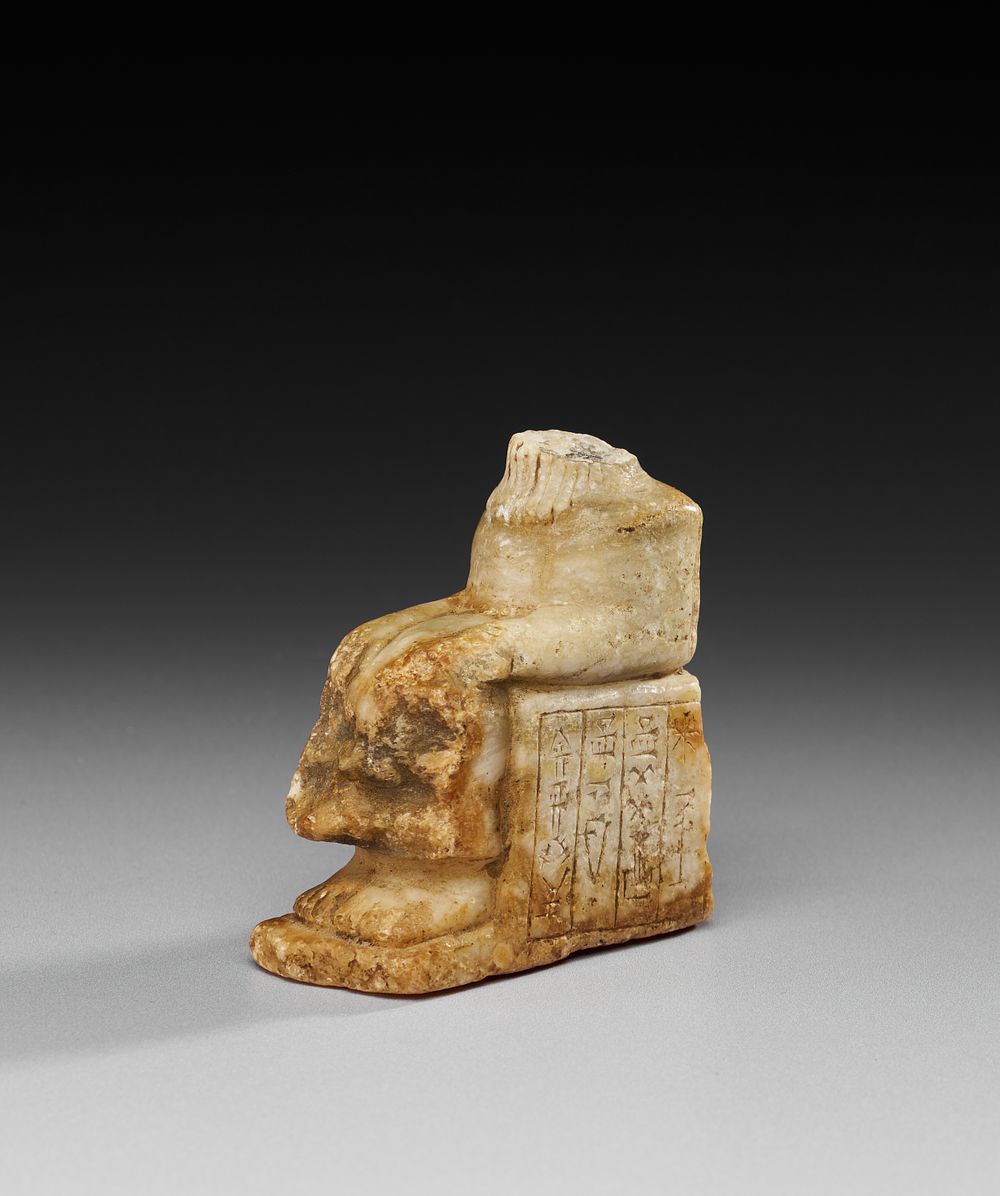 Lot 219: A CUNEIFORM INSCRIBED WHITE MARBLE FRAGMENT OF A SEATED FIGURE, MESOPOTAMIA, 2600 B.C.