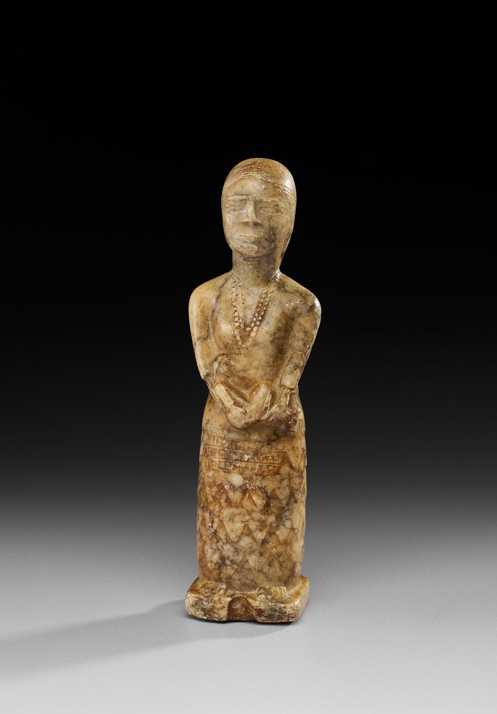 Lot 222: A MESOPOTAMIA WHIT MARBLE FIGURE OF A FEMALE WORSHIPPER, 2600 - 2400 B.C.