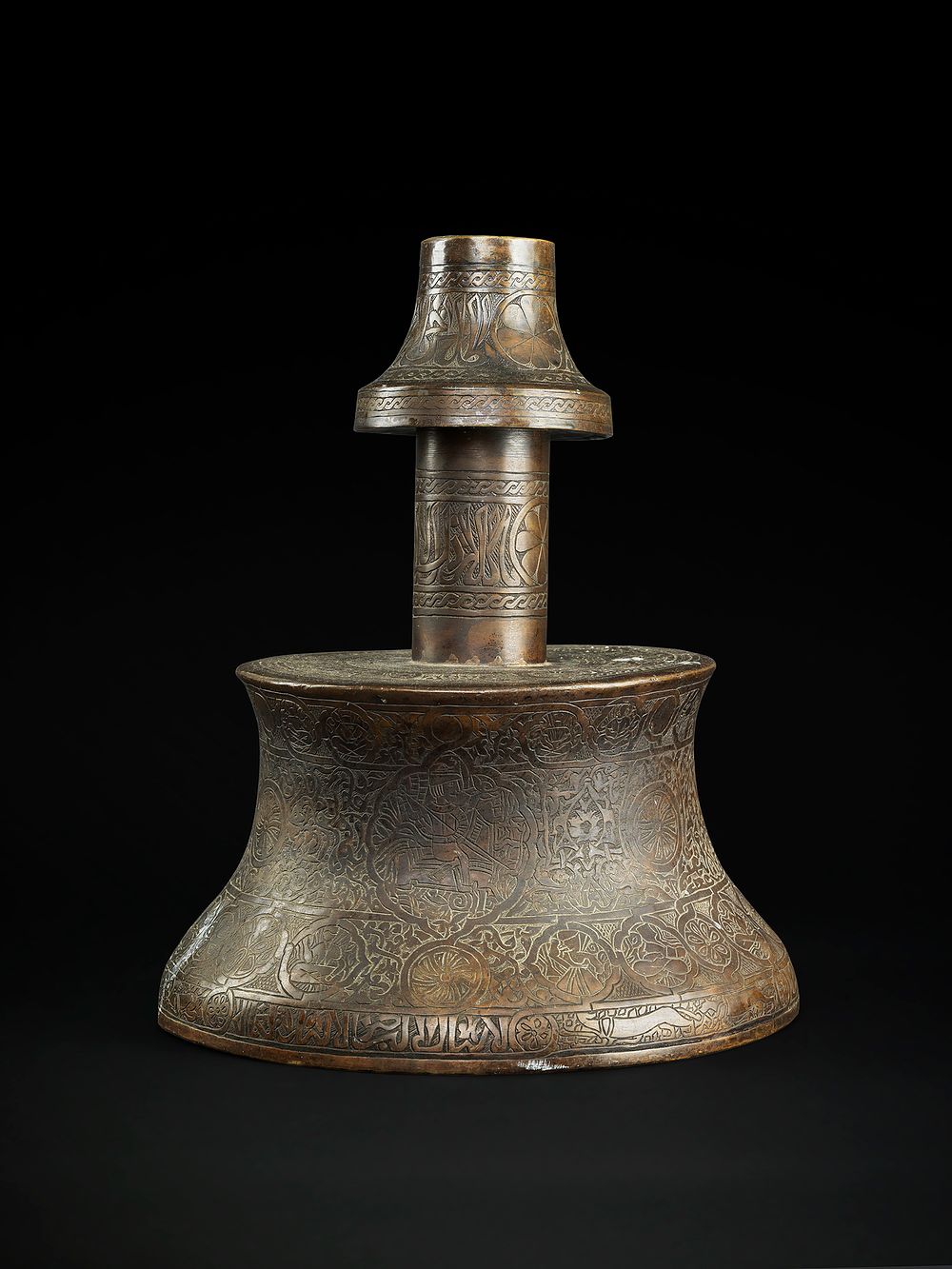 Lot 213: A LARGE BRASS CANDLESTICK WITH CALLIGRAPHY AND DRAWINGS, SYRIA OR EGYPT, 19TH CENTURY