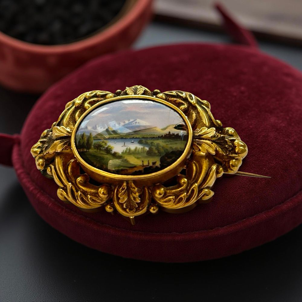 Lot 343: 15ct Gold Victorian mourning brooch (?) with a hand painted landcape scene panel.
