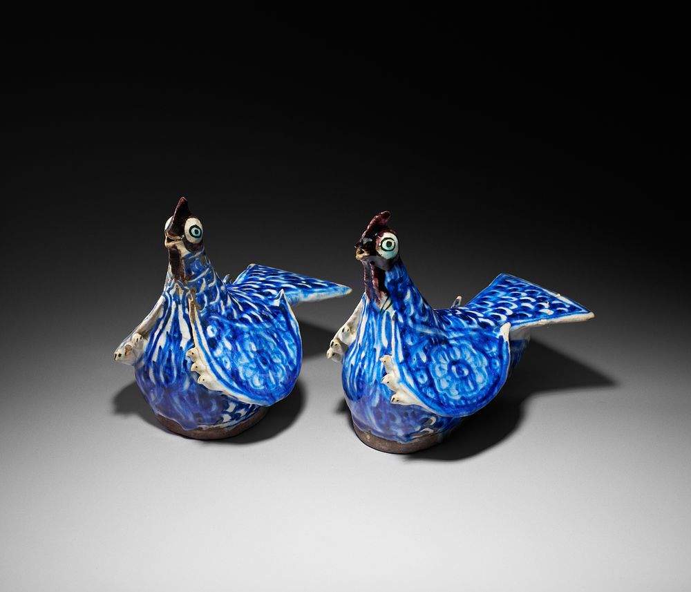 Lot 156: A PAIR OF QAJAR BLUE AND WHITE MOULDED POTTERY BIRDS FIGURES, 19TH CENTURY
