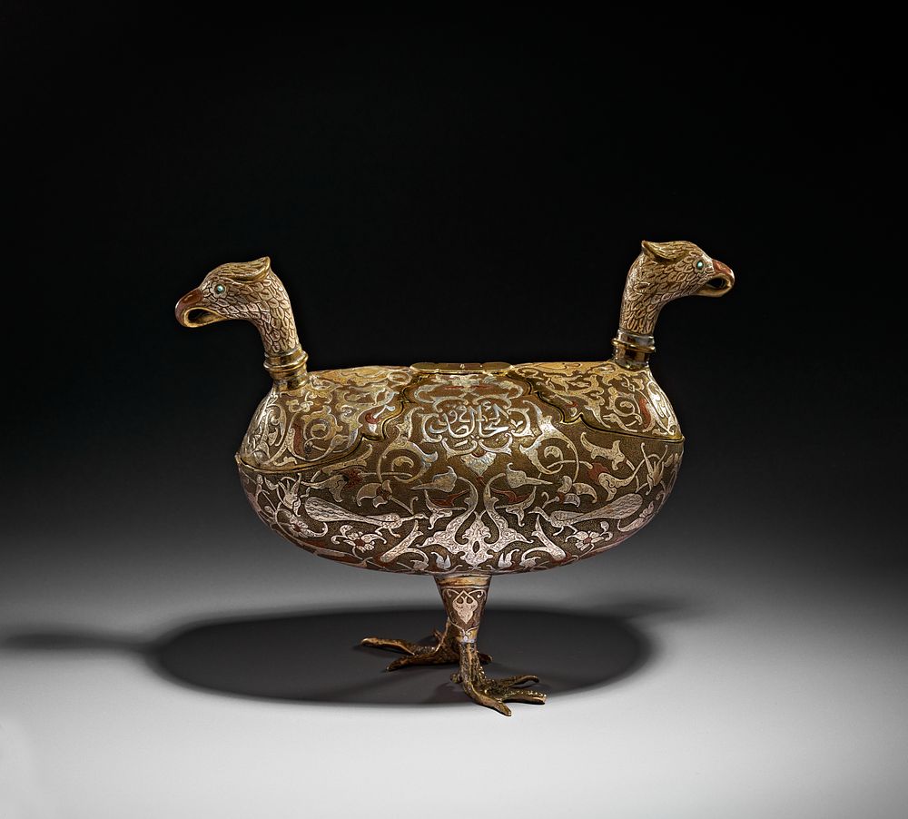 Lot 198: A DAMASCUS SILVER AND COPPER INLAID BRASS KASHKUL IN THE FORM OF TWO EAGLES, SYRIA, 20TH CENTURY