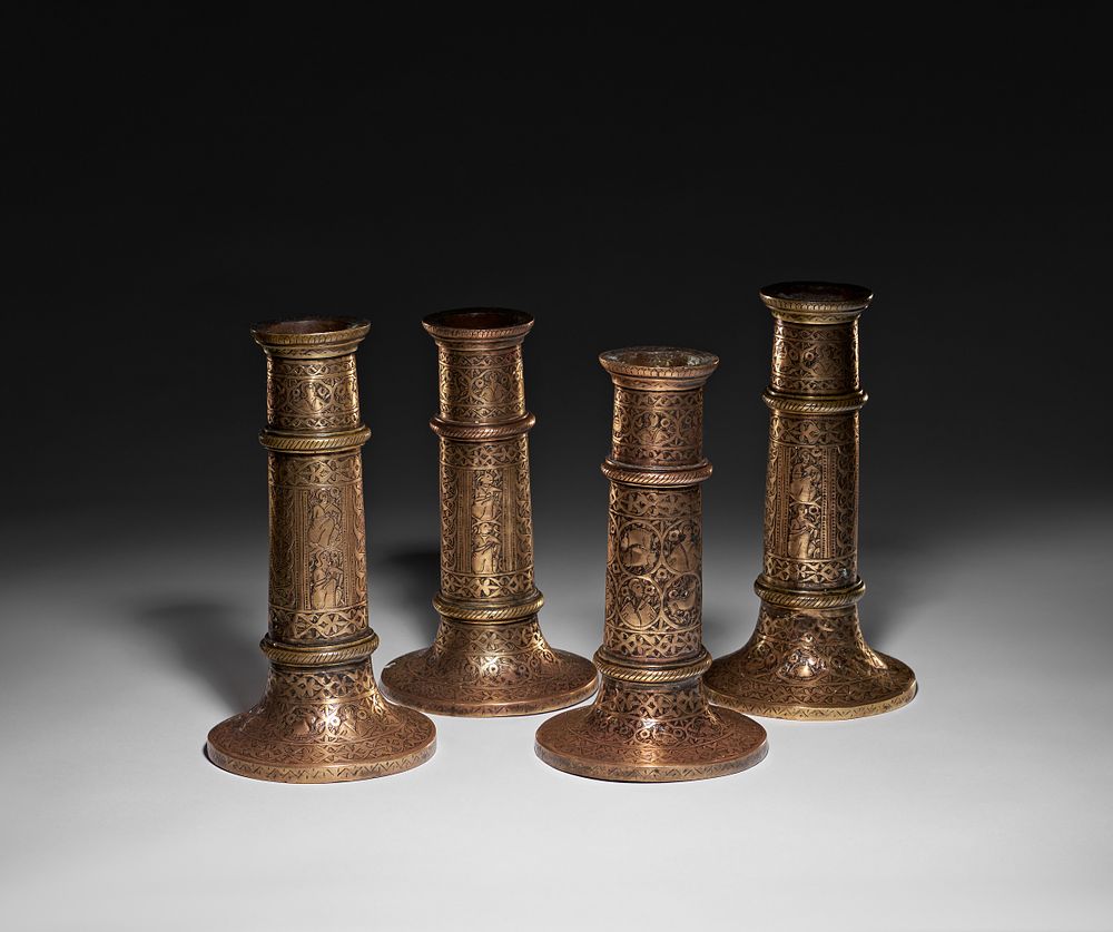 Lot 253: A SET OF FOUR ENGRAVED QAJAR BRASS TORCH STAND, PERSIA, 19TH CENTURY
