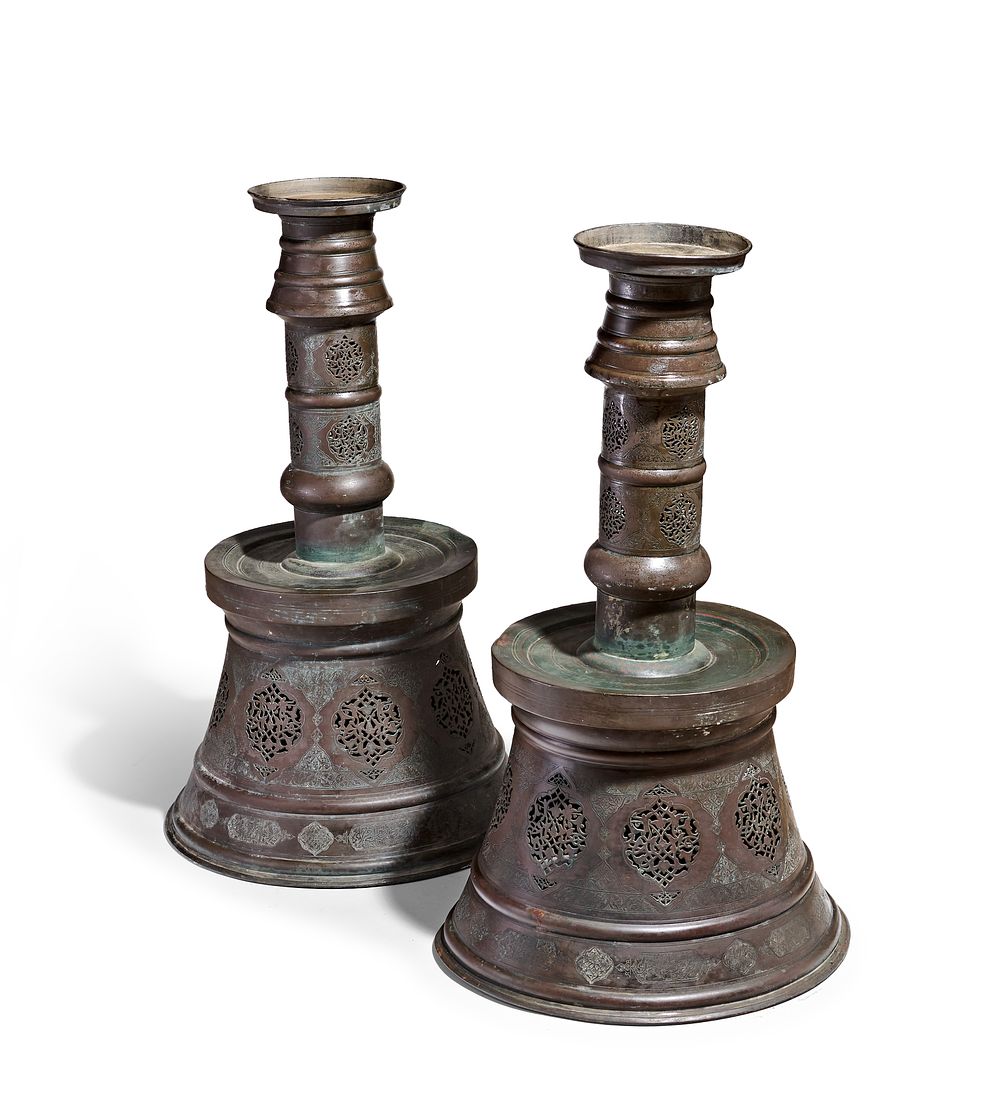 Lot 258: A MONUMENTAL PAIR OF MAMLUK STYLE PIERCED COPPER ALLOY CANDLESTICKS, 19TH - 20TH CENTURY