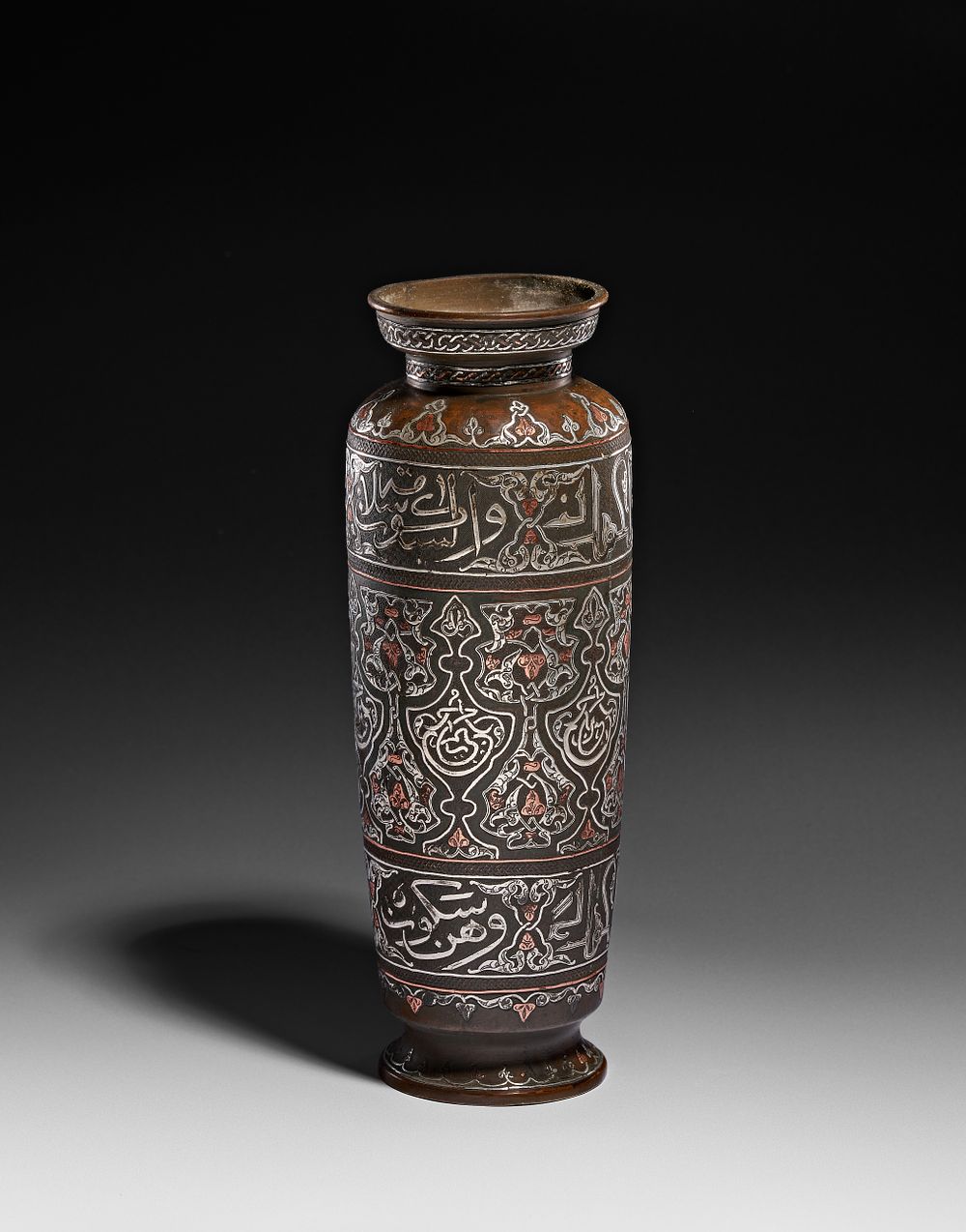 Lot 267: AN EGYPTIAN MAMLUK STYLE SILVER AND COPPER INLAID BRASS VASE, CIRCA 1900