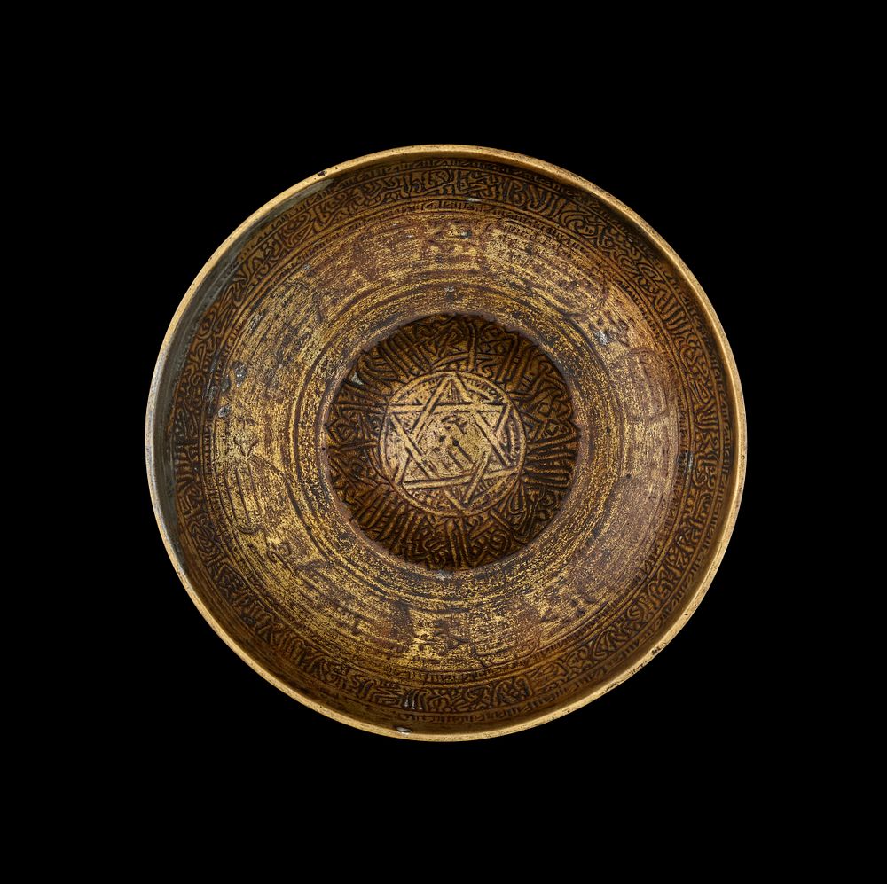 Lot 284: A MAMLUK ENGRAVED BRASS MAGIC BOWL, EGYPT, 15TH-16TH CENTURY