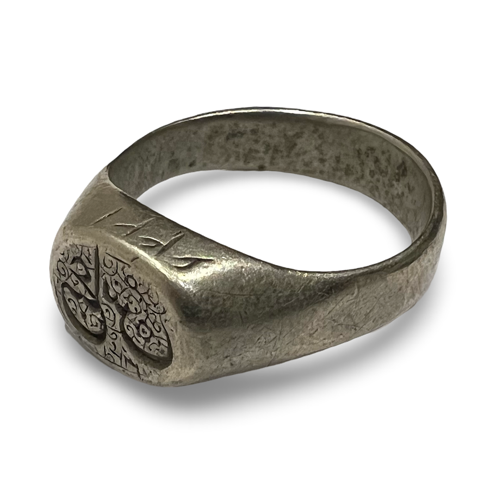 Lot 261: A SILVER-TONED SIGNET RING WITH ENGRAVED MOTIF AND RUNIC STYLE SHOULDER MARKS
