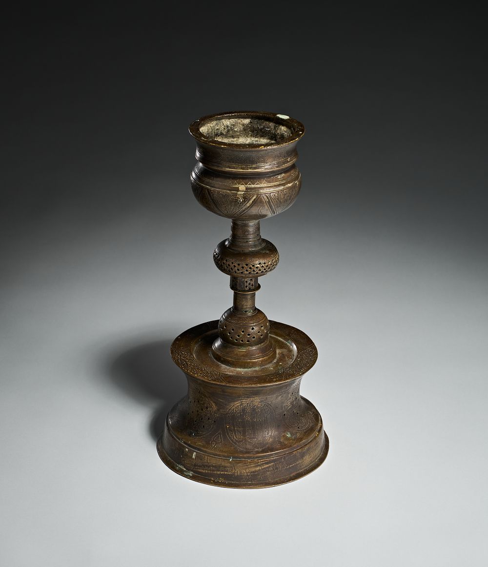 Lot 269: AN ISLAMIC ENGRAVED COPPER ALLOY CANDLESTICK, PROBABLY TURKEY, 19TH CENTURY