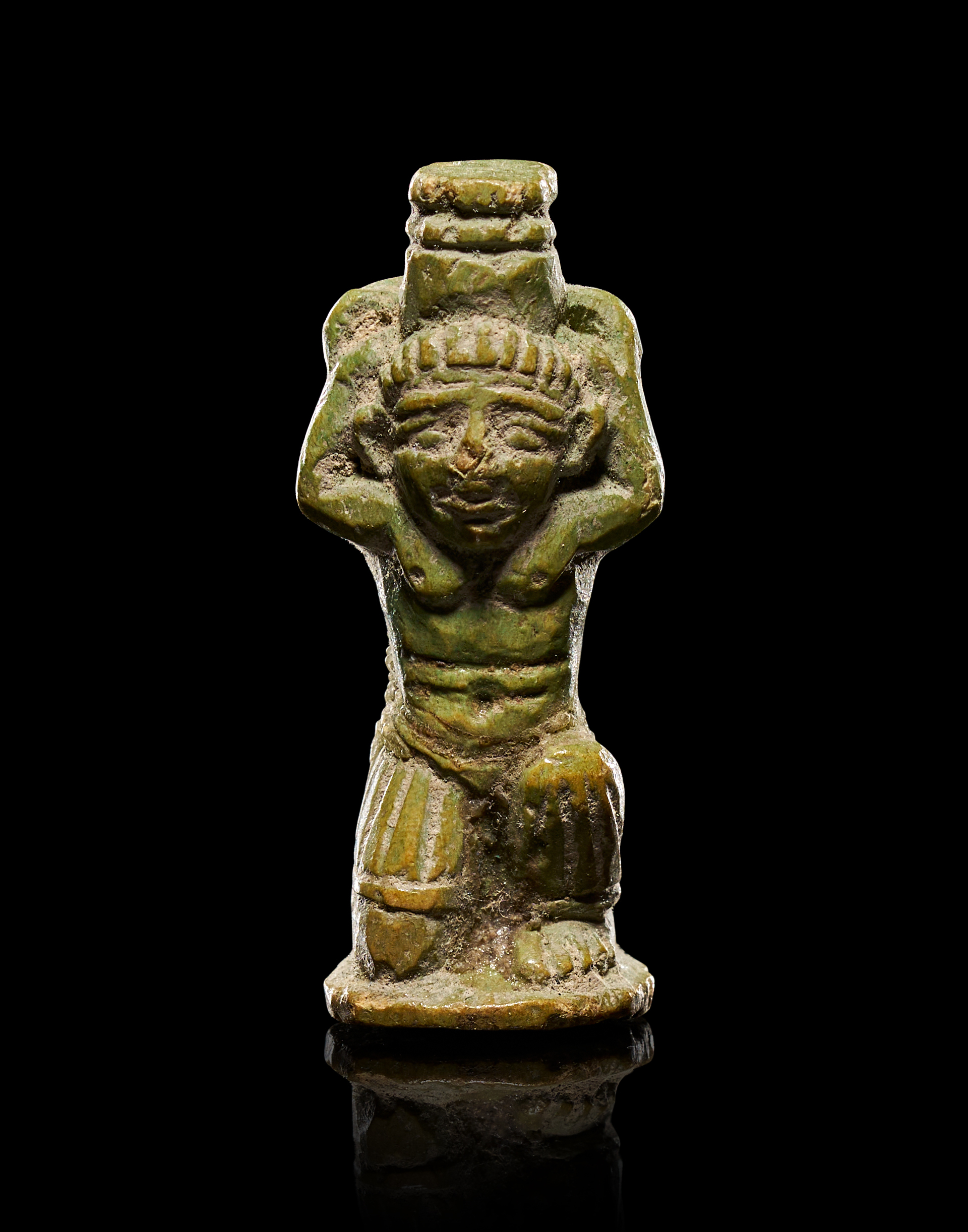 AN ANCIENT EGYPTIAN GREEN-GLAZED FAIENCE AMULET OF A KNEELING DEITY, LATE PERIOD, CIRCA 664-332 B.C.