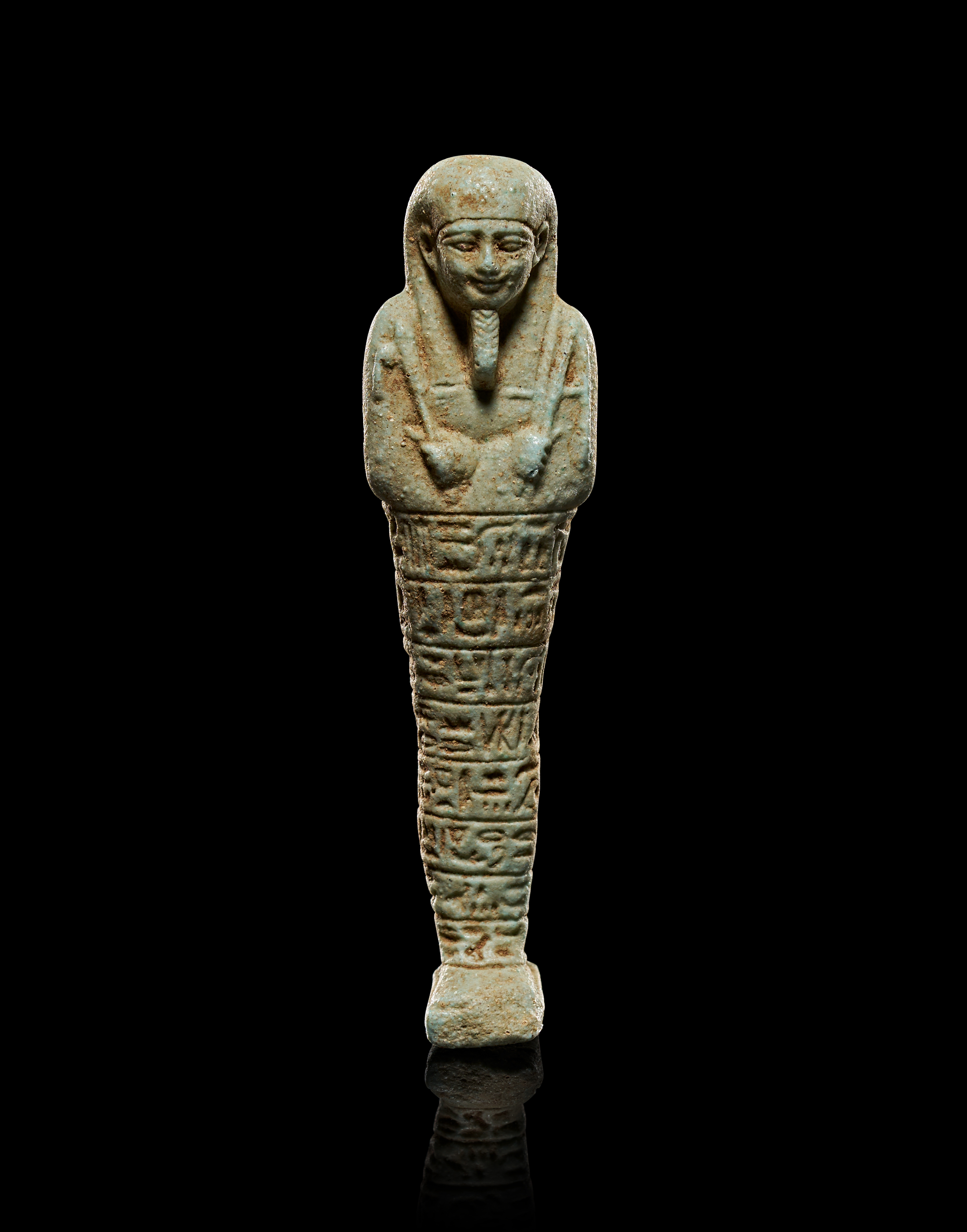 AN EGYPTIAN PALE GREEN GLAZED FAIENCE USHABTI, LATE PERIOD, CIRCA 664–332 BC