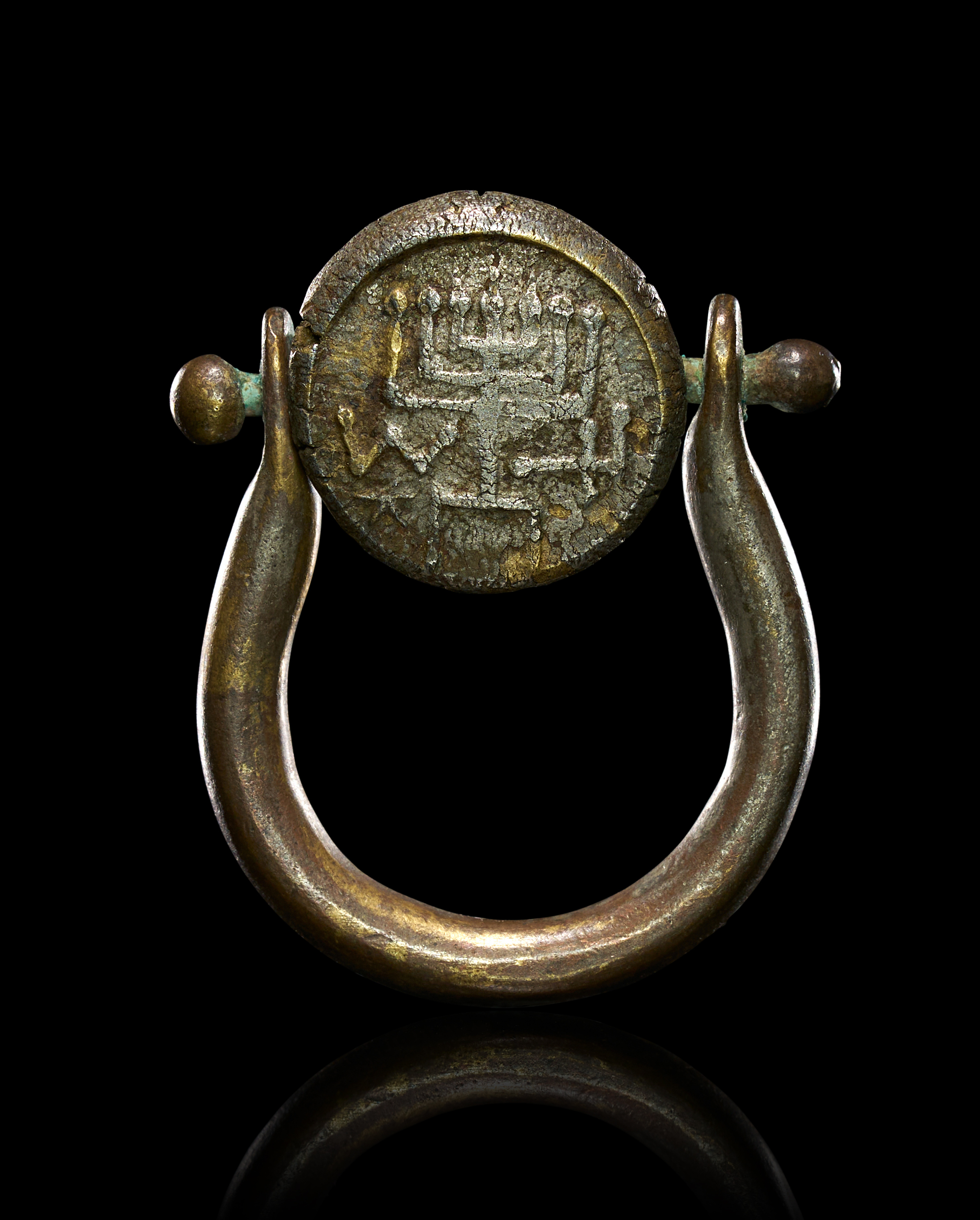 A RARE BRONZE SWIVEL SEAL RING WITH HASMONEAN MENORAH MOTIF, CIRCA 3RD CENTURY B.C.