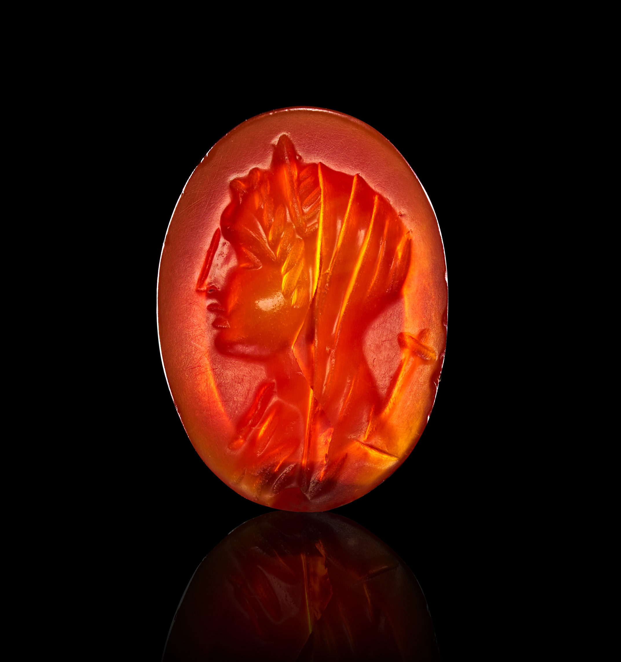 A ROMAN OVAL CARNELIAN INTAGLIO DEPICTING A VEILED CLASSICAL FIGURE, 1ST - 2ND CENTURY A.D.