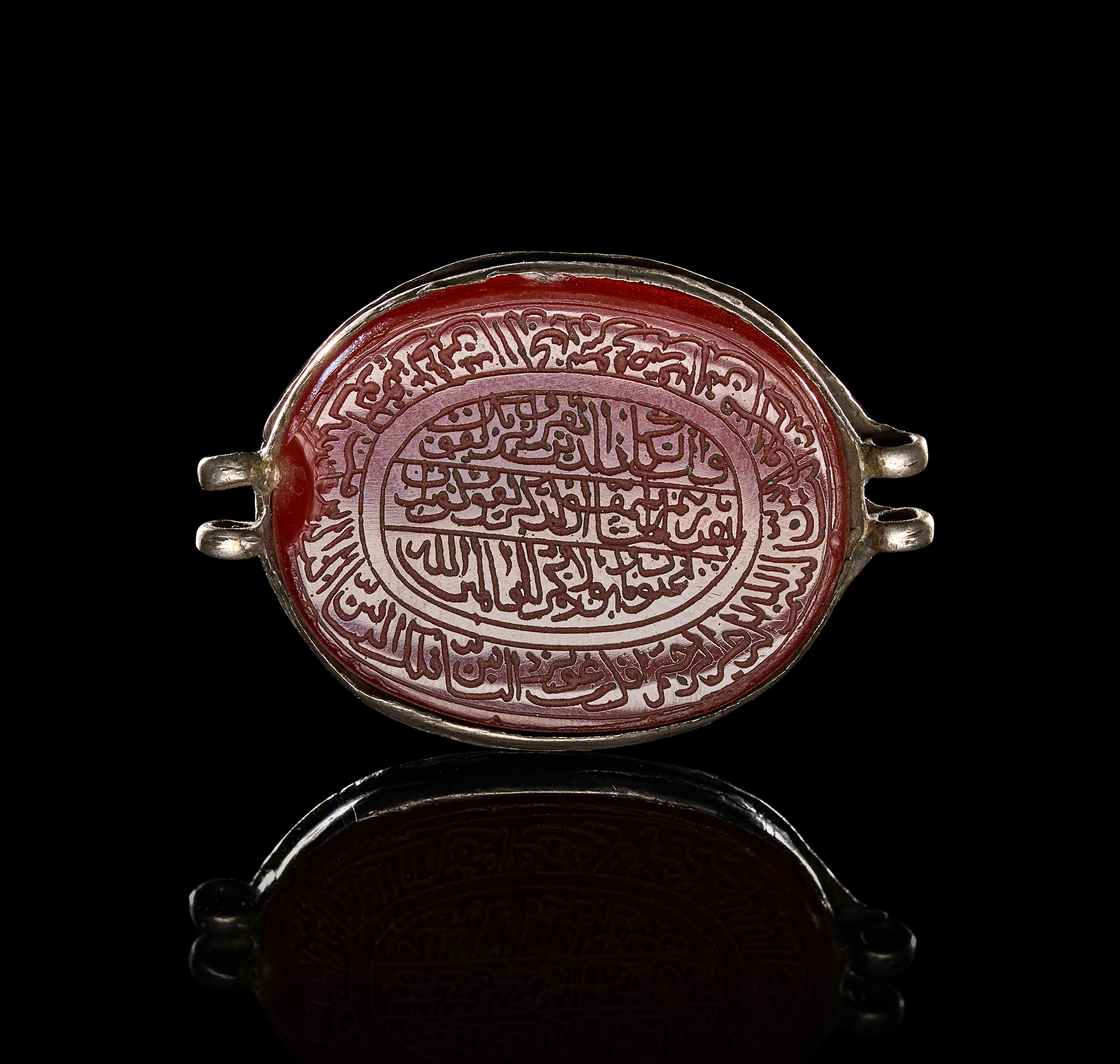 AN ISLAMIC INSCRIBED CARNELIAN AND SILVER BAZUBAND ELEMENT, PERSIA, 19TH CENTURY