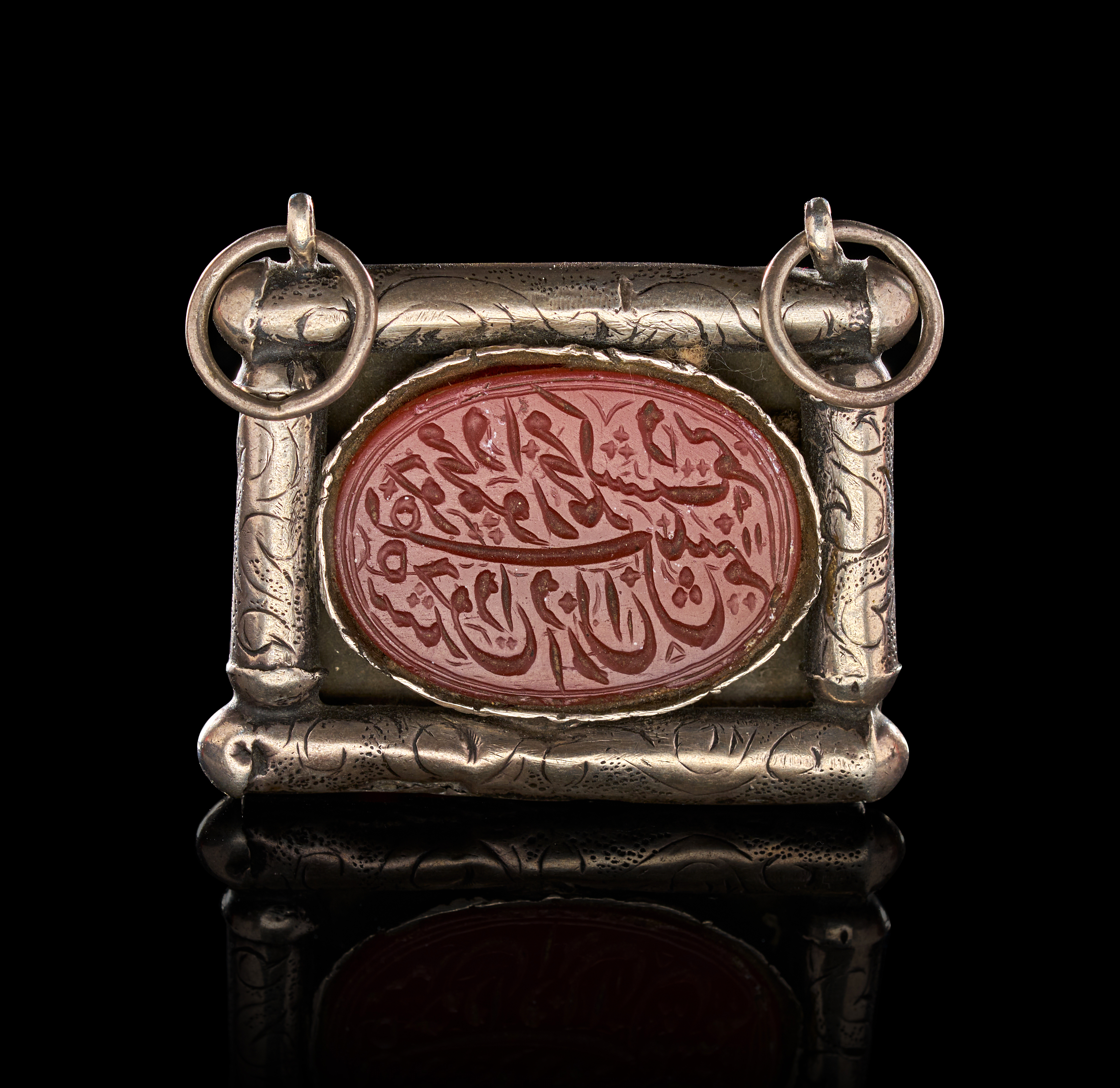 AN ISLAMIC SILVER AND CARNELIAN TALISMANIC PENDANT, PERSIA, 19TH CENTURY