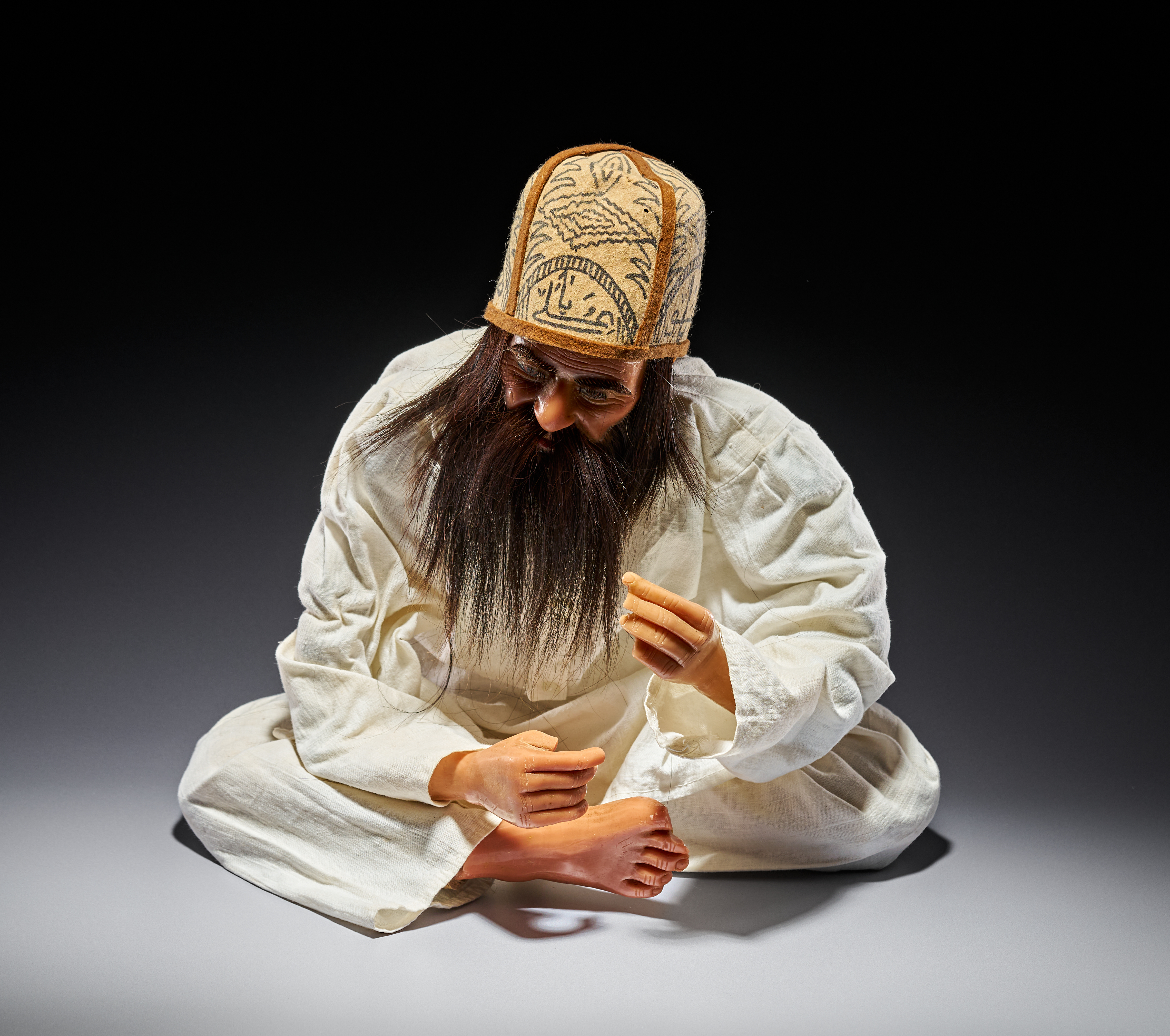 A PERSIAN SEATED MODEL OF A SUFI DERVISH, 20TH CENTURY