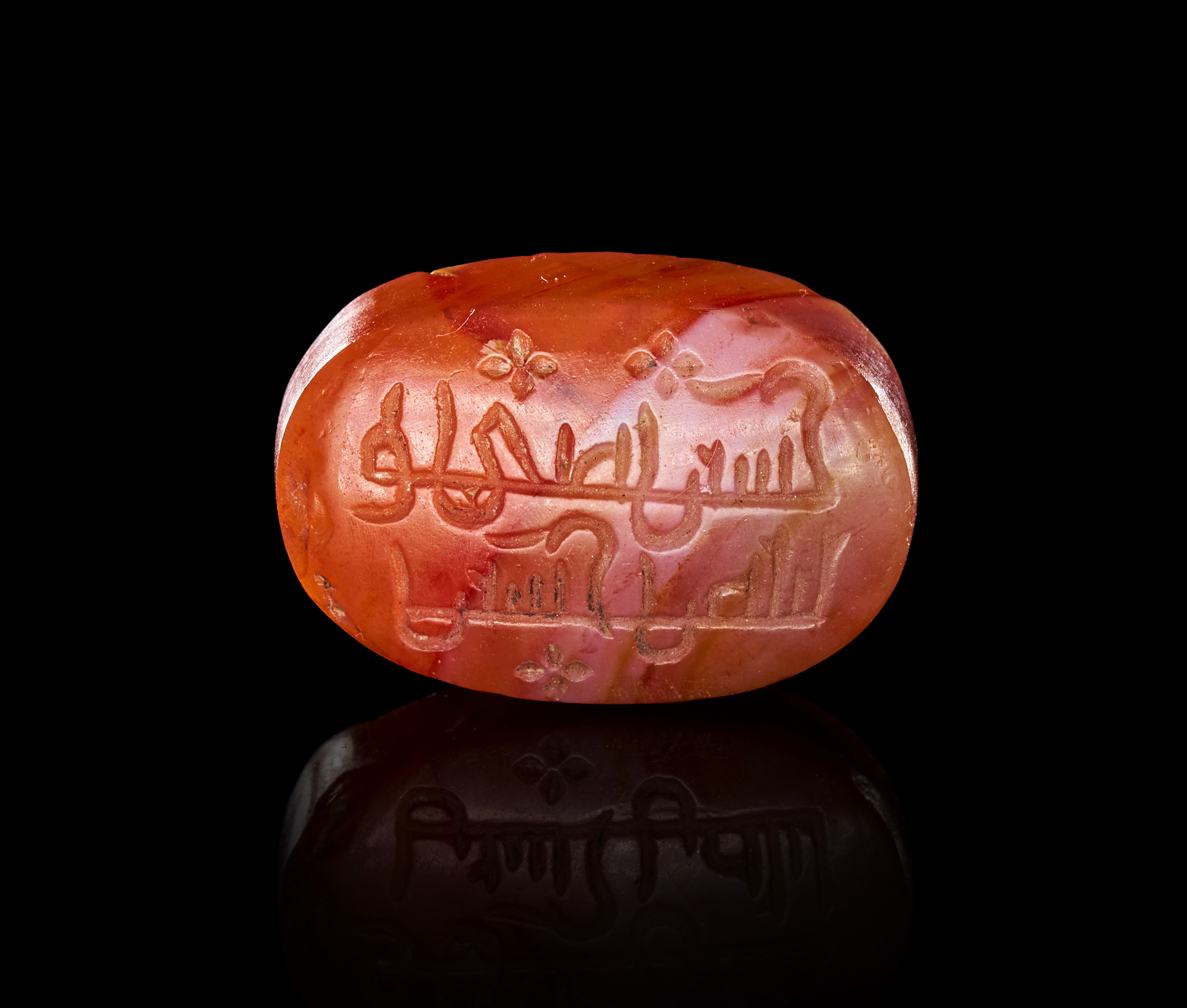 AN ISLAMIC CARNELIAN AGATE INTAGLIO SEAL STONE WITH CALLIGRAPHIC INSCRIPTION