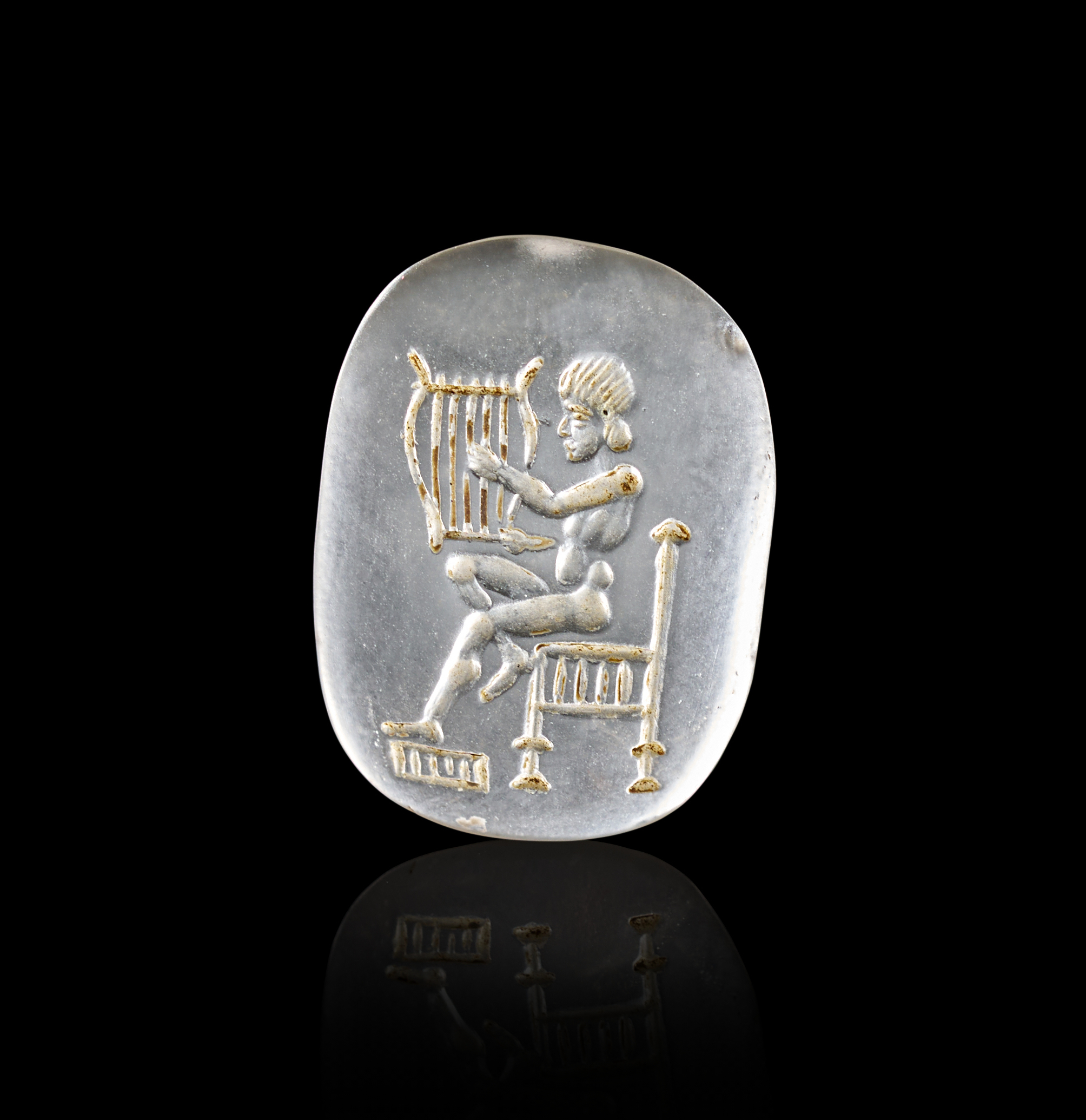 A GREEK ROCK CRYSTAL INTAGLIO DEPICTING A SEATED MUSICIAN, CIRCA 1ST - 2ND CENTURY A.D. OR LATER