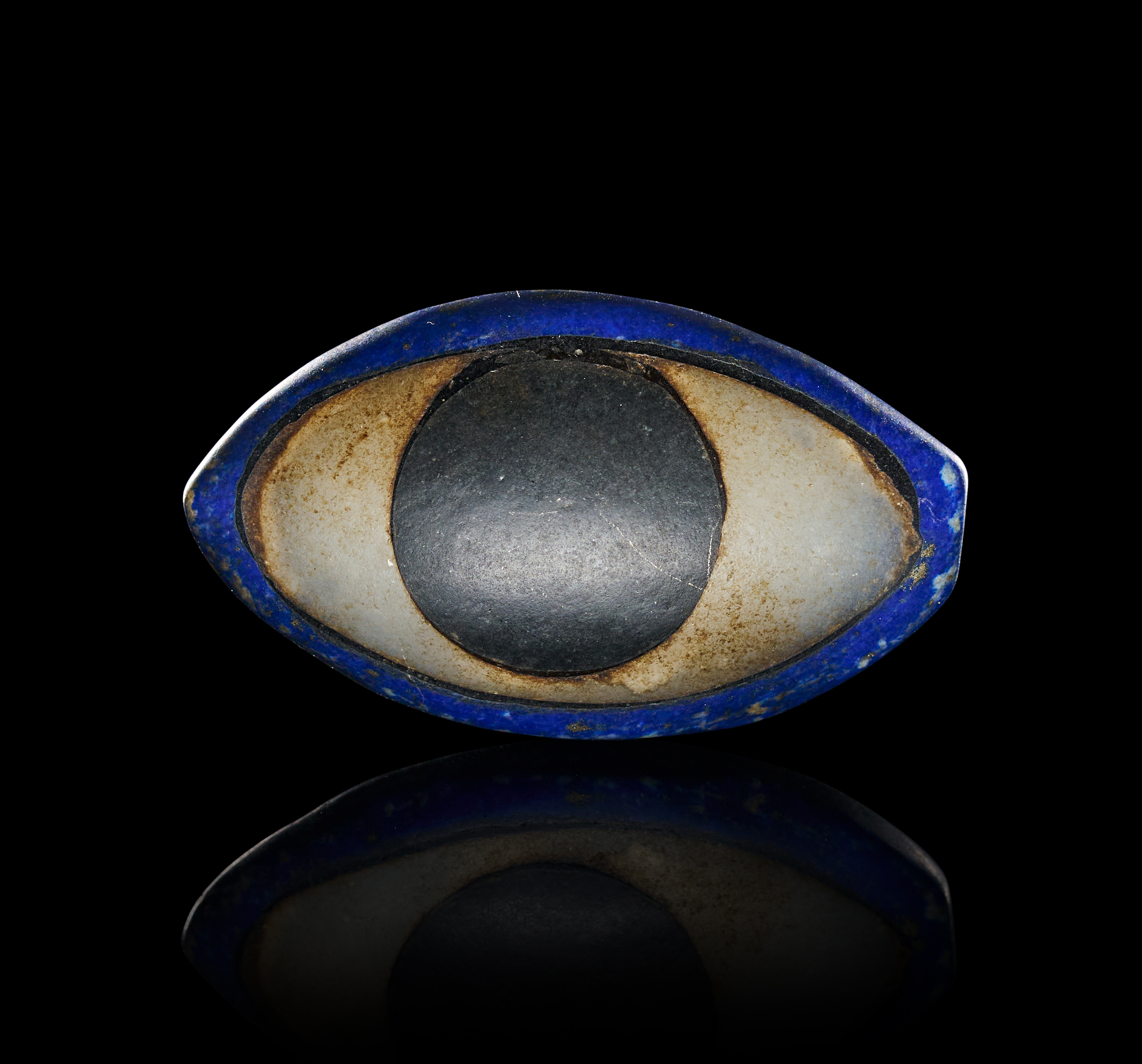 A RARE MESOPOTAMIAN LAPIS LAZULI, LIMESTONE AND BLACK STONE EYE INLAY, EARLY DYNASTIC, CIRCA 2600-2250 B.C.