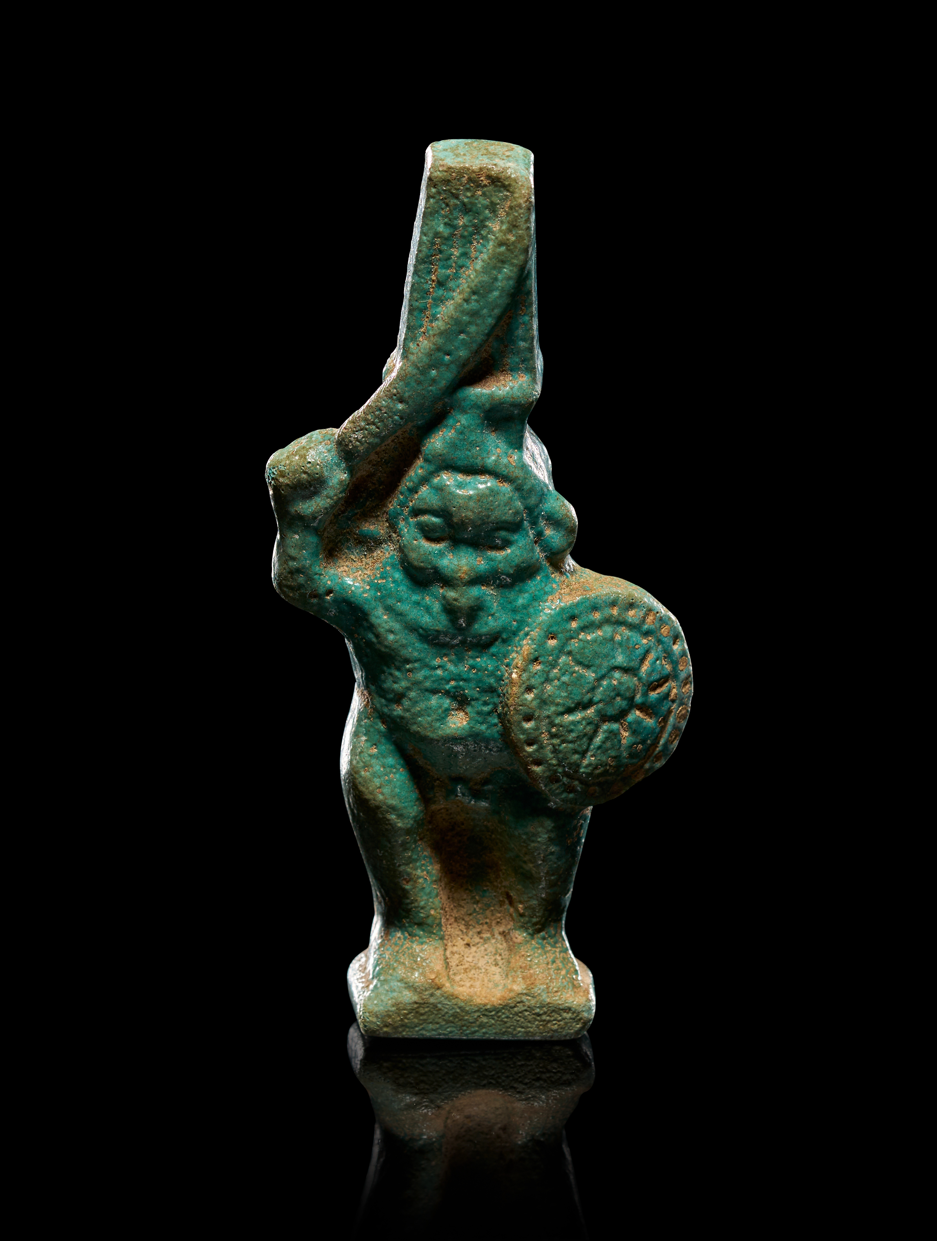 AN EGYPTIAN FAIENCE AMULET OF THE GOD BES,  LATE PERIOD, CIRCA 664-332 B.C.