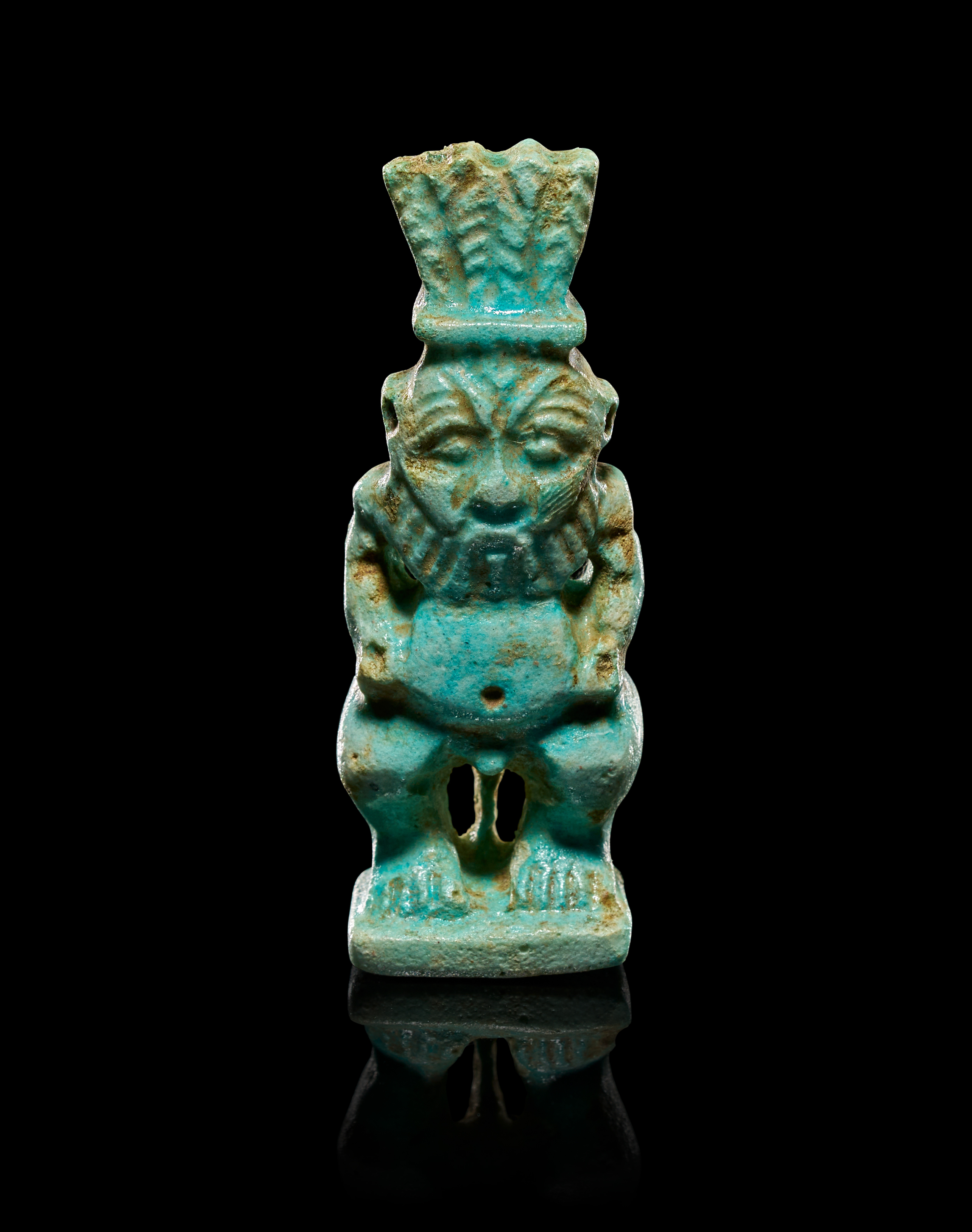AN EGYPTIAN FAIENCE AMULET OF THE DEITY BES, LATE PERIOD, CIRCA 664-332 B.C.
