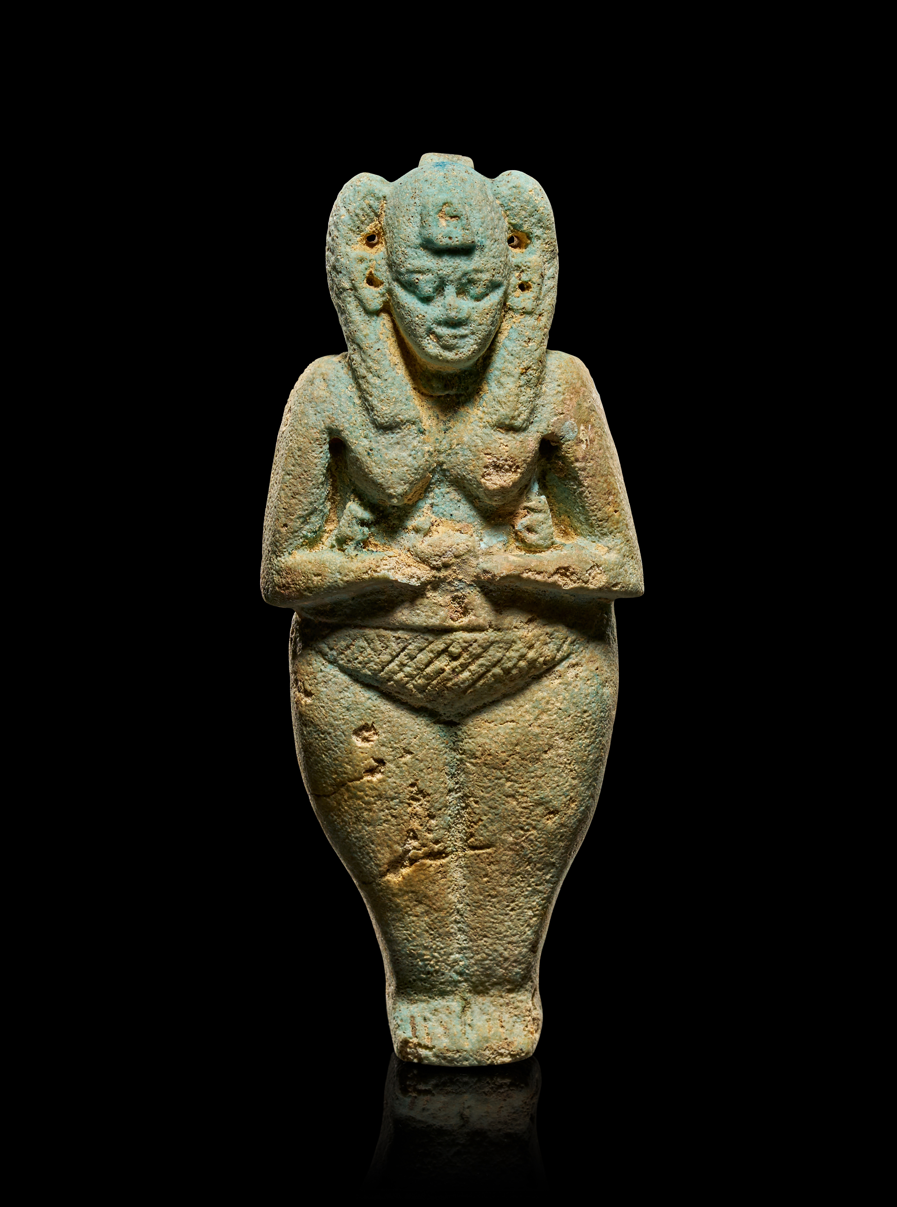 AN EGYPTIAN TURQUOISE FAIENCE FIGURINE OF A NUDE FEMALE HOLDING MONKEYS, THIRD INTERMEDIATE PERIOD, CIRCA 1070 - 644 BCE