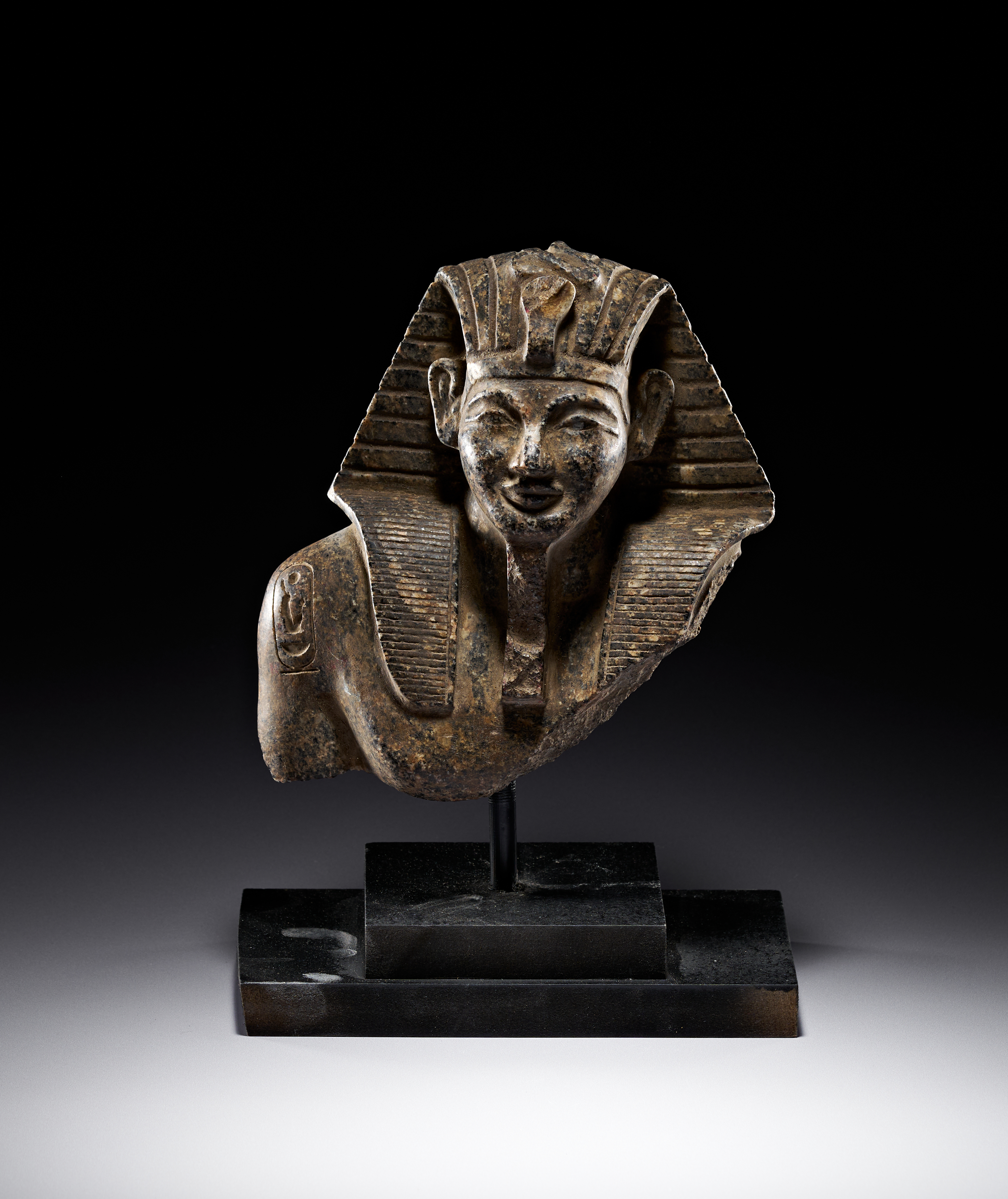 AN EGYPTIAN GRANITE HEAD OF A ROYAL OFFICIAL NEW KINGDOM, REIGN OF AMENOPHIS III, 1391-1351 B.C.