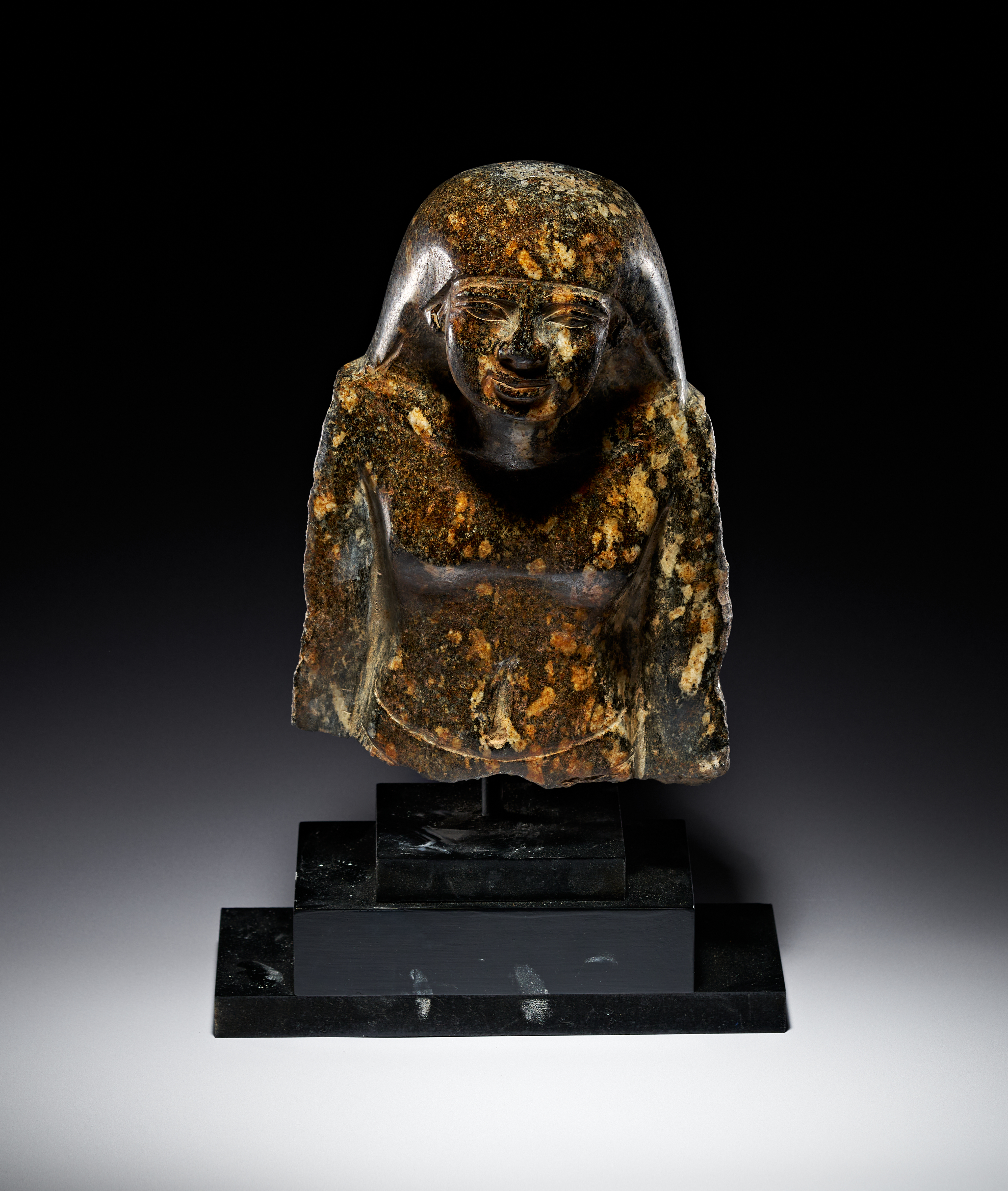 A EGYPTIAN BLACK GRANITE OF A SEATED OFFICIAL, 30TH DYNASTY TO PTOLEMAIC PERIOD, 4TH - 3RD CENTURY B.C