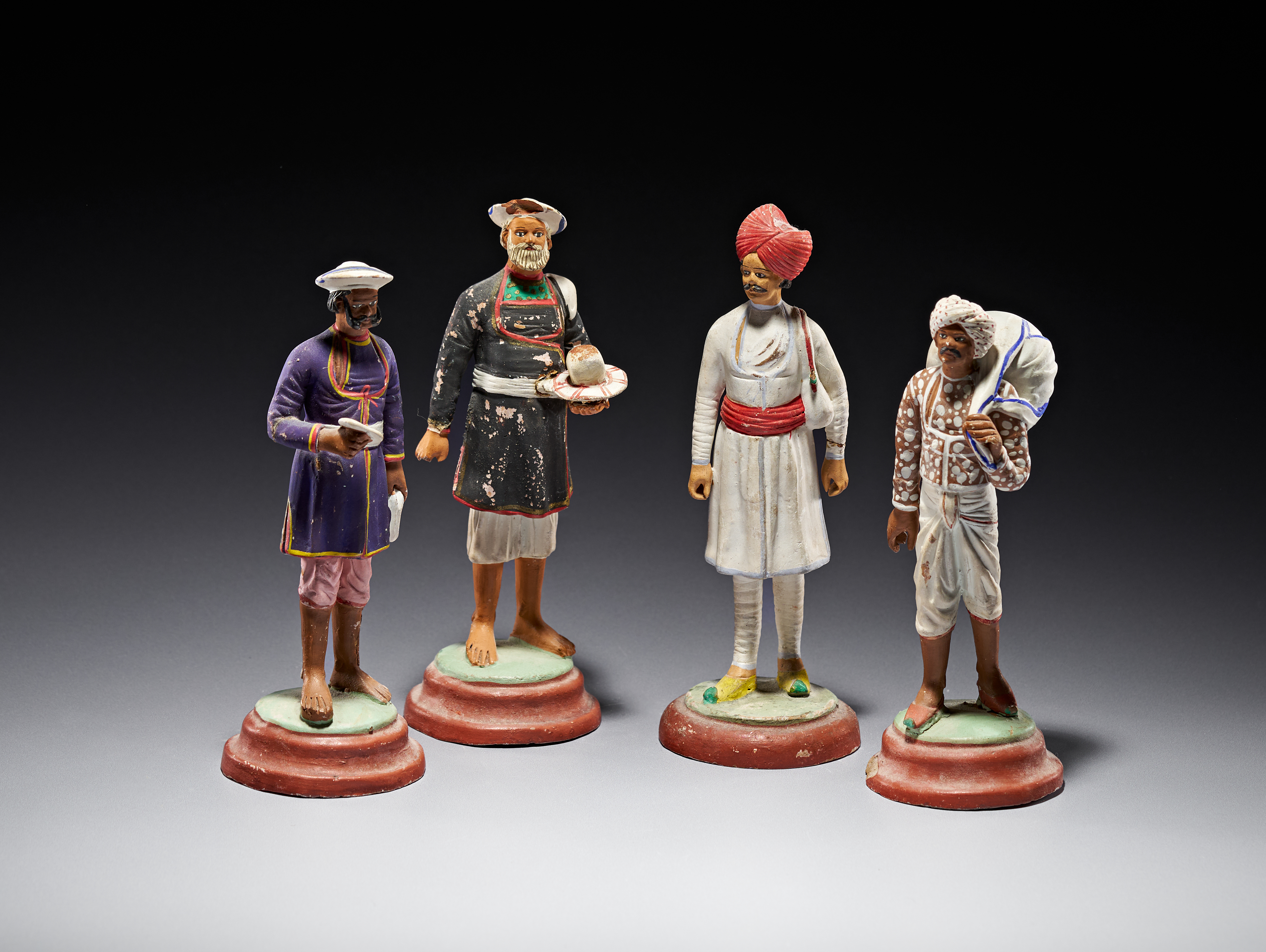 A SET OF FOUR INDIAN POLYCHROME TERRACOTTA OCCUPATION FIGURINES IN THE STYLE OF KRISHNANAGAR, 19TH CENTURY