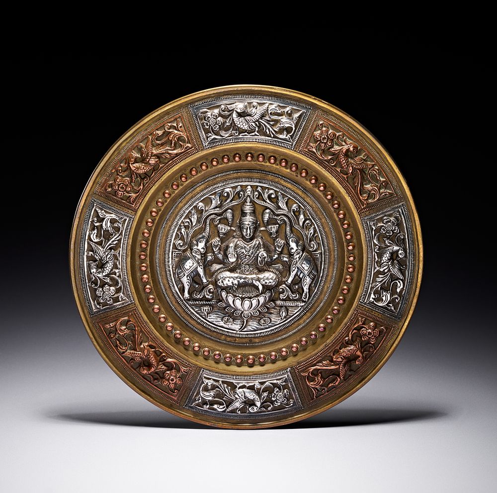 Lot 231: A SOUTH INDIAN THANJAVUR SILVER AND COPPER ENCRUSTED BRASS PLATE, LATE 19TH CENTURY