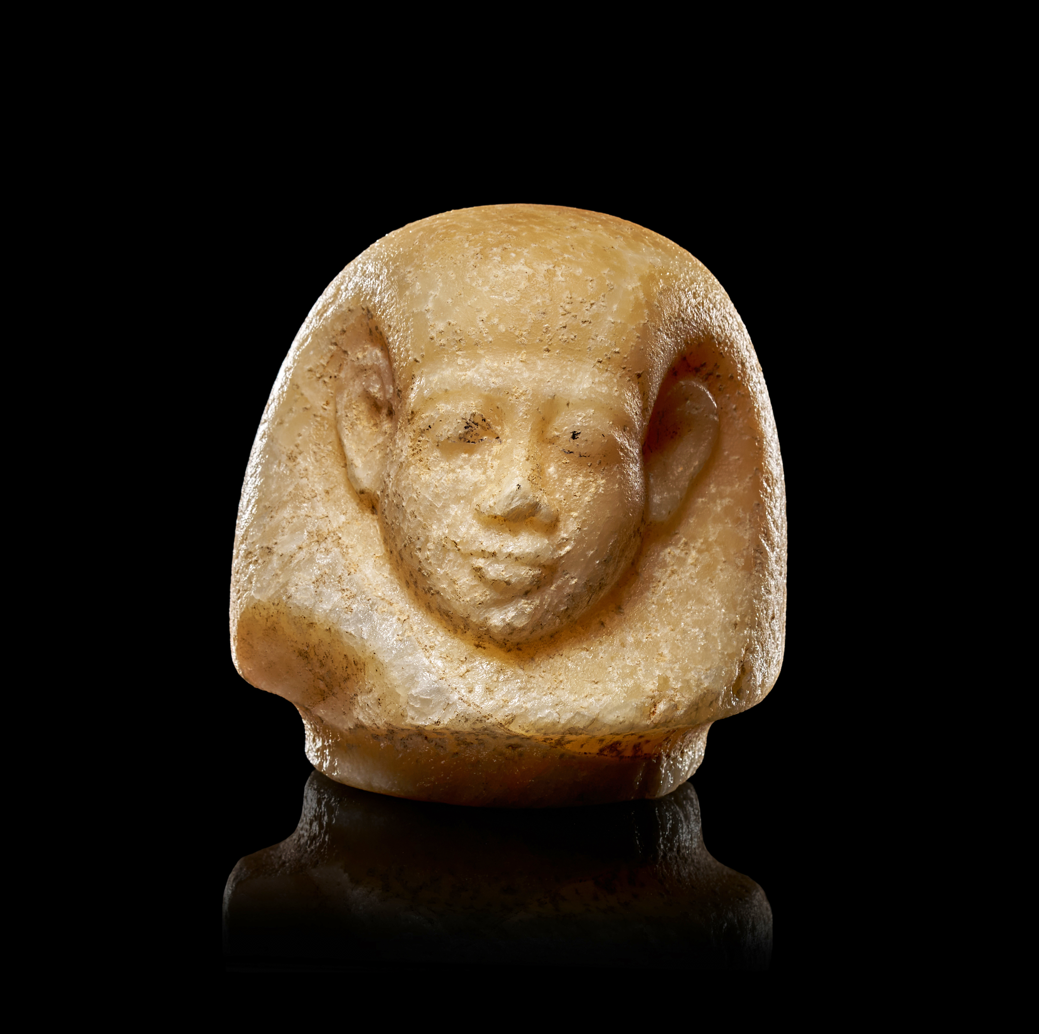 AN EGYPTIAN ALABASTER CANOPIC JAR LID OF HUMAN-HEADED IMSETY, NEW KINGDOM, 18TH DYNASTY, CIRCA 1550-1292 B.C.