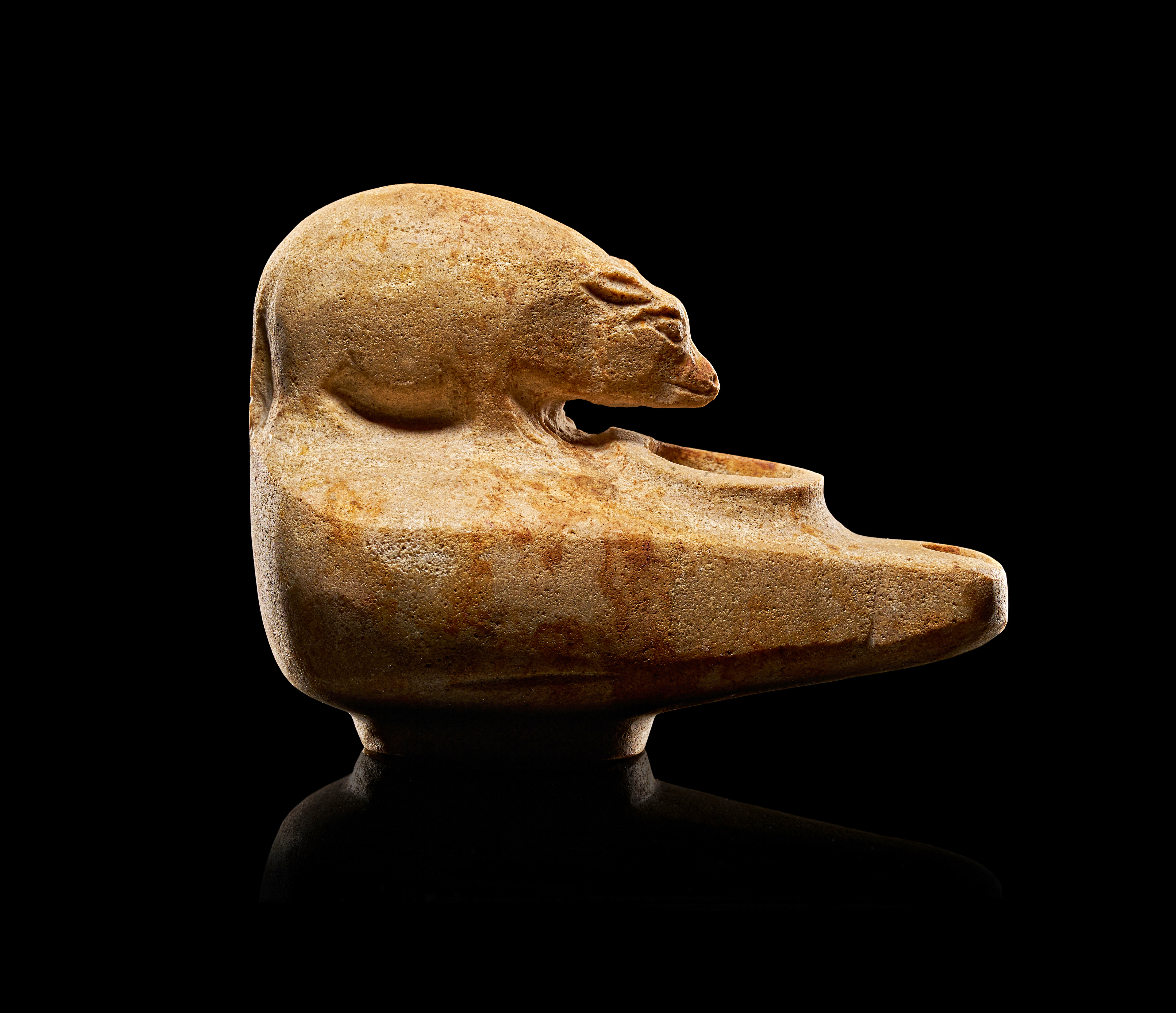 A SOFT STONE EGYPTIAN OIL LAMP CARVED WITH A RECLINING ANIMAL, EASTERN ROMAN PERIOD, 3RD CENTURY A.D.