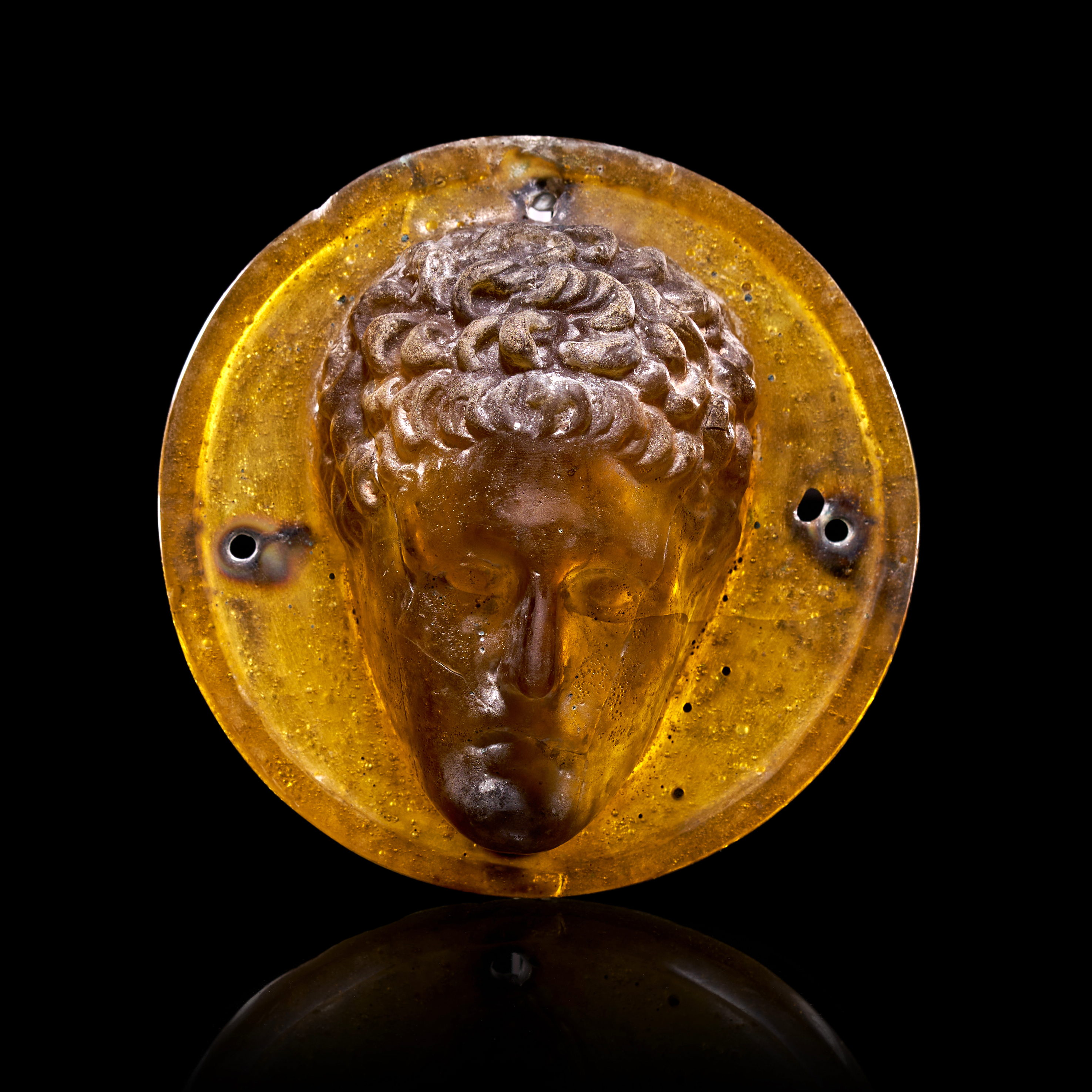 A ROMAN GLASS APPLIQUE HEAD OF A YOUTH, CIRCA 3RD CENTURY A.D.