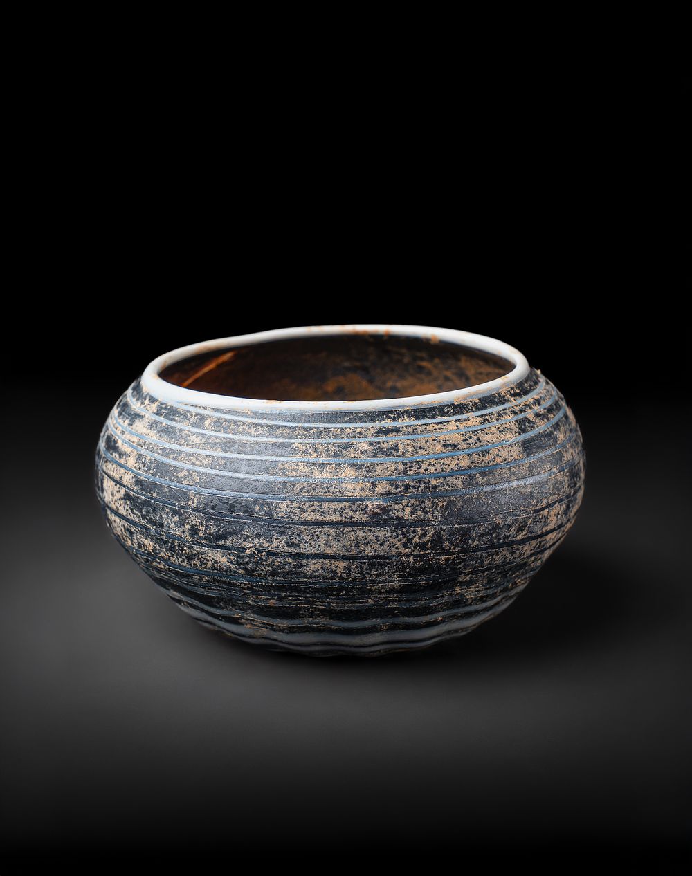 Lot 168: AN EARLY ISLAMIC MARVERED GLASS BOWL, POSSIBLY MAMLUK
