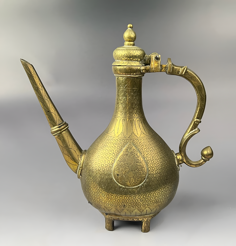Lot 184: A NORTH INDIAN BRASS AFTABA EWER WITH CHASED BIRD AND FLORAL DECORATION, 19TH CENTURY