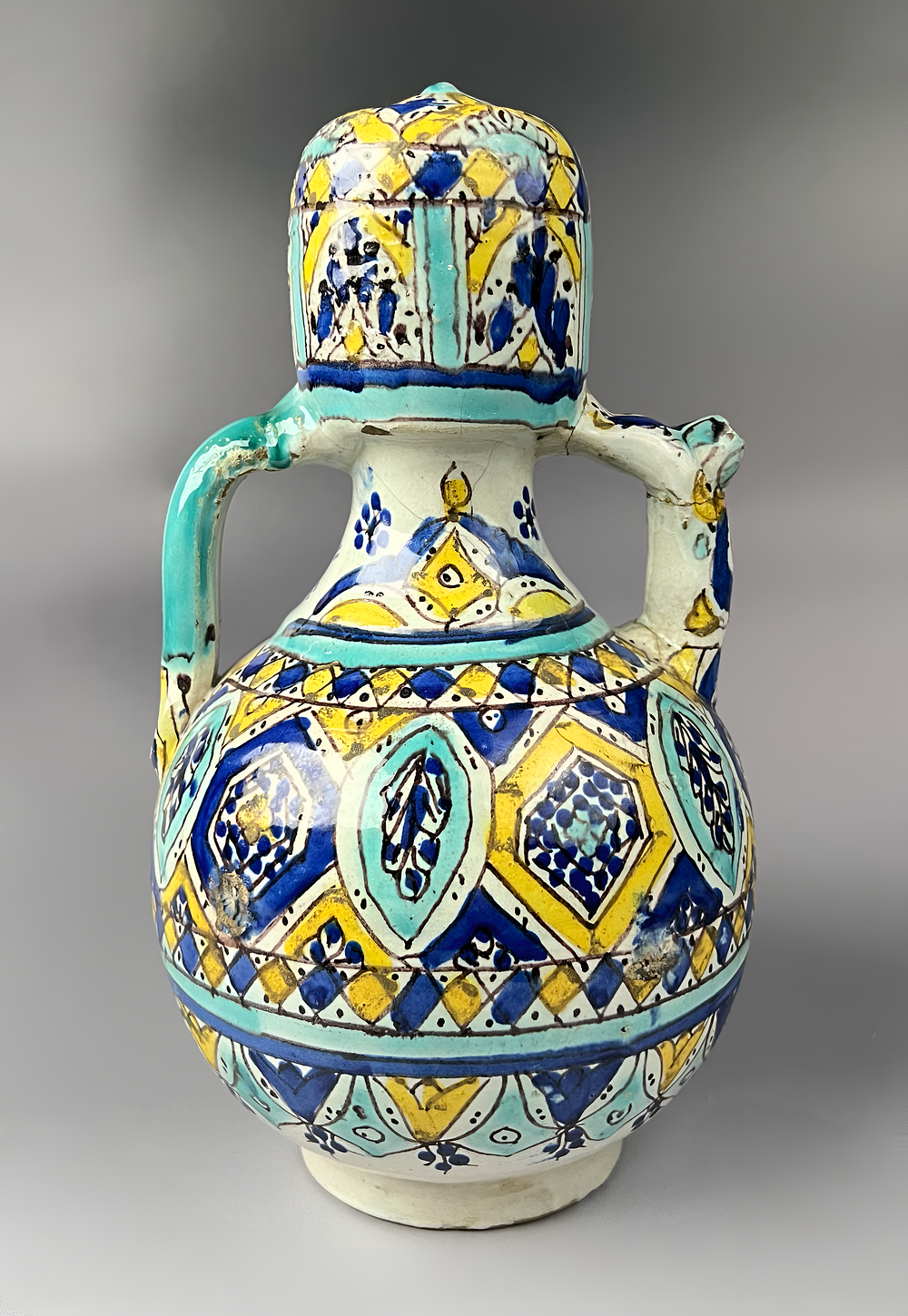 Lot 160: A MOROCCAN FEZ POLYCHROME GLAZED CERAMIC TWIN HANDLED WATER JUG, 19TH CENTURY