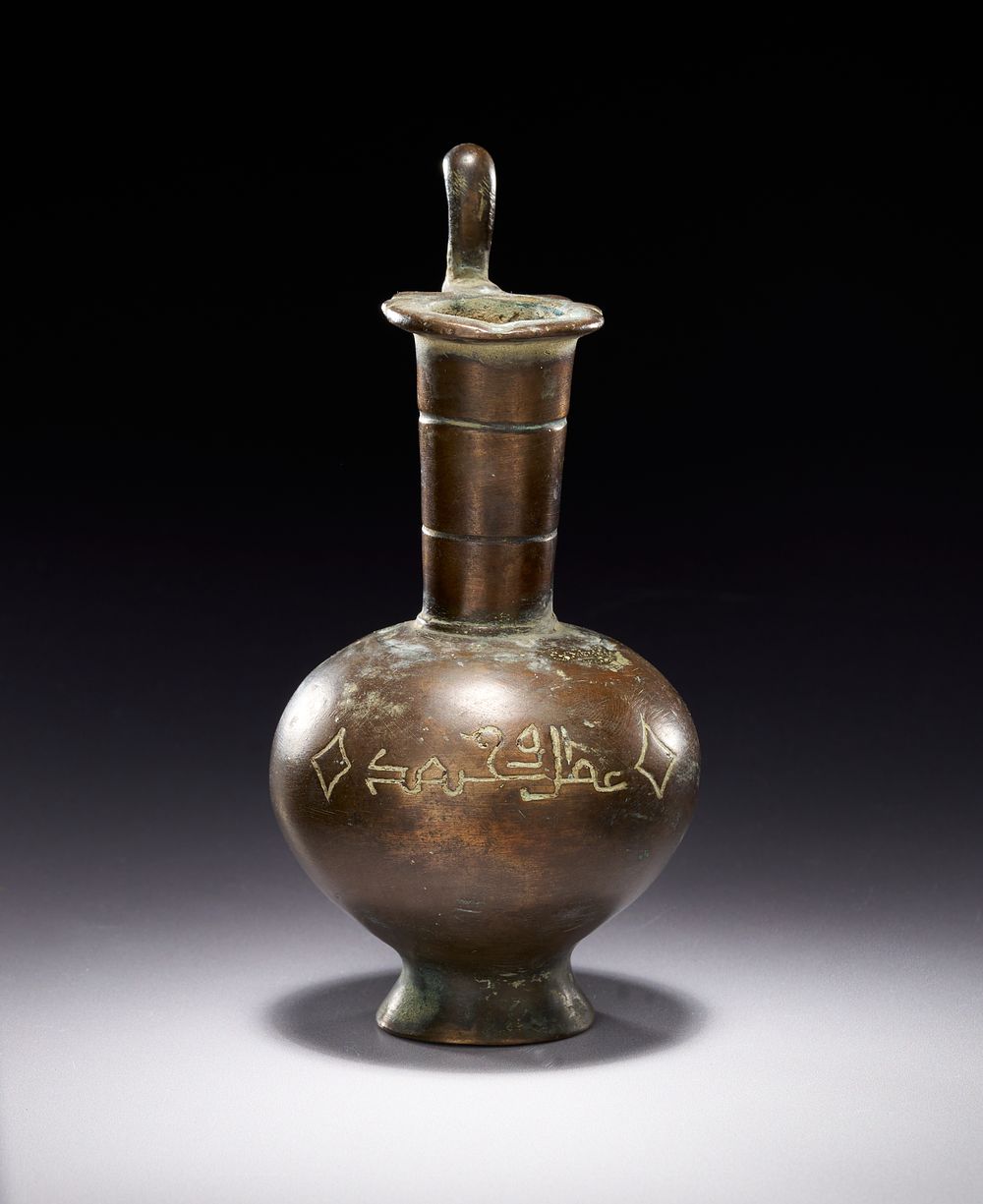 Lot 175: A MINIATURE UMAYYAD OR EARLY ABBASID BRONZE EWER WITH KUFIC INSCRIPTIONS, 8TH-9TH CENTURY