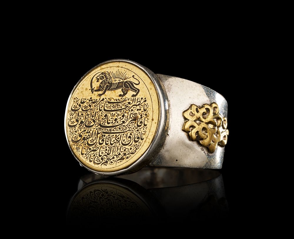 Lot 269: A PERSIAN PARCEL-GILT SILVER SIGNET RING WITH LION AND SUN MOTIF