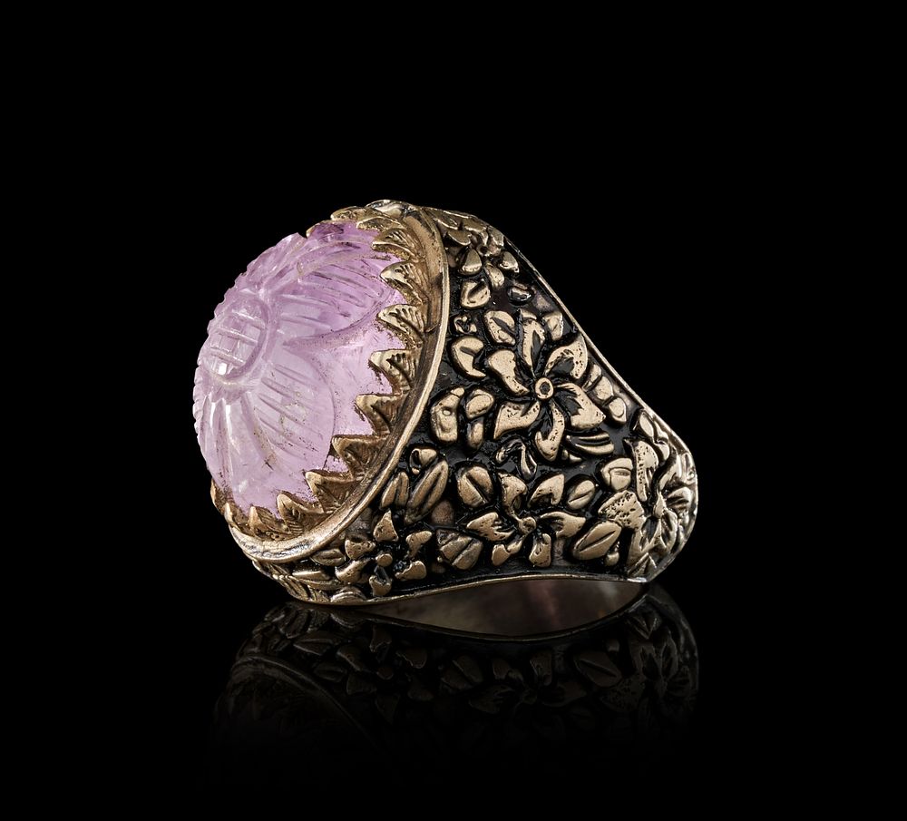 Lot 277: A CARVED AMETHYST GEMSTONE IN A FLORAL SILVER RING, INDIA, 19TH CENTURY