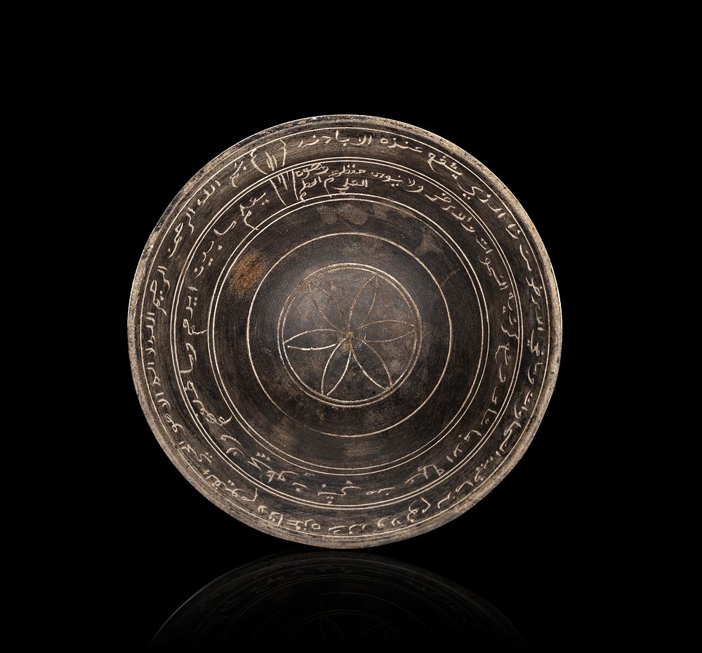 Lot 248: A JERUSALEM BITUMINOUS LIMESTONE FOOTED BOWL WITH ARABIC AND ITALIAN INSCRIPTIONS, BETHLEHEM, LATE 19TH - EARLY 20TH