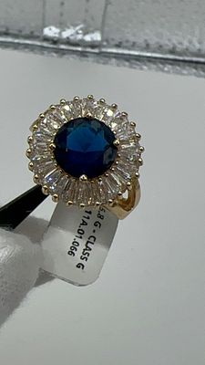 טבעת זהב גולדפילד צהוב 14 ק. בשיבוץ אבן ספיר כחולה במרכז ומסביב אבני זירקוניה בליטוש באגט