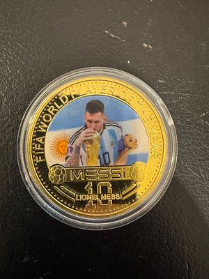 Lionel Messi – Gold-Tone Fantasy Coin, 2022 World Cup. A gold-tone fantasy coin with color print 