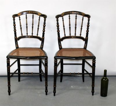 Pair of French ebonized side chairs with caned seats. Gold floral decoration. Late 19th 