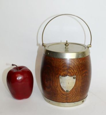 Antique English oak biscuit barrel with shield crest dated 1915. Silverplate rim, lid and 