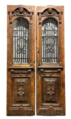 Pair Continental carved doors with iron panels. One side carved with figural masks. From The 