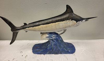 hand carved Marlin leaping out of water by J Lupton. the fish is mounted atop a carved and 