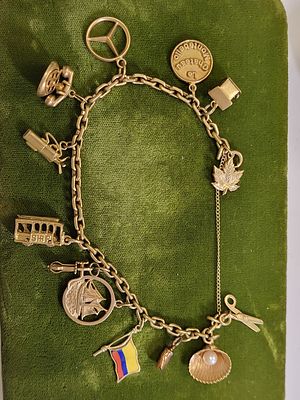 14K yellow gold charm bracelet Mercedes, cable car. golf, old telephone charm le cheatau 