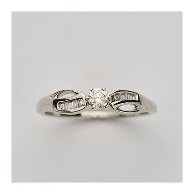 Sortija en oro blanco con diamante central talla brillante engastado en garras y brazos calados 