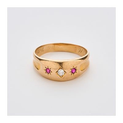 Sortija en oro con diamante talla brillante antigua custodiado por símiles de rubí talla