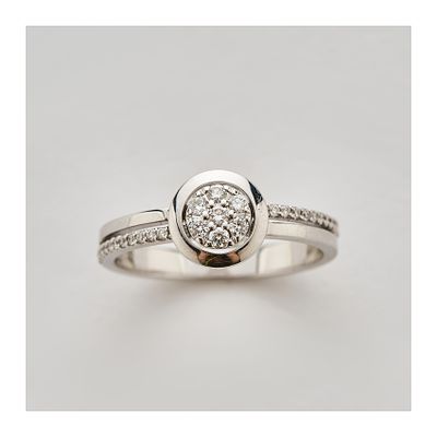 Sortija en oro blanco con centro circular y brazos calados de diamantes talla brillante. Peso