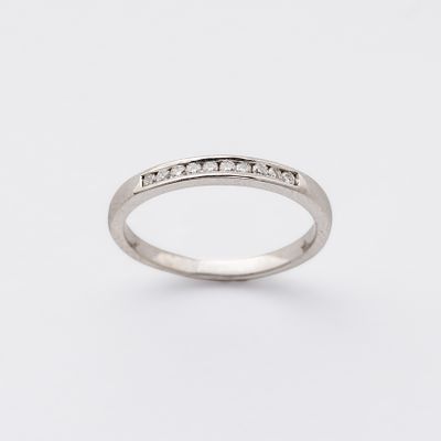 Sortija media alianza en oro blanco con diamantes talla brillante engastados en carril. Peso 